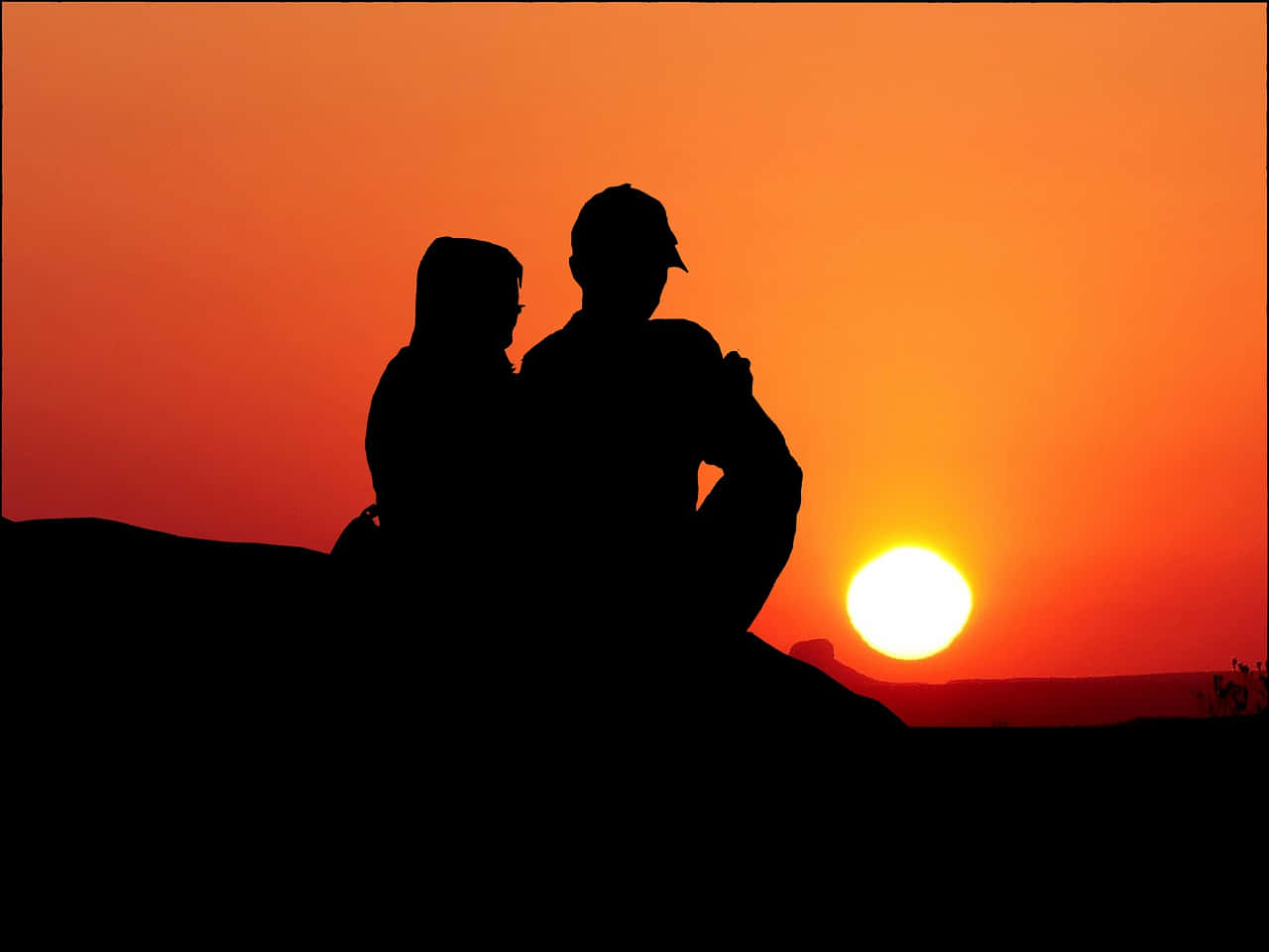 太陽 桌布 壁紙 — 一對情侶以剪影形式在山丘上擁抱，背後夕陽以火熱的橙色落下。