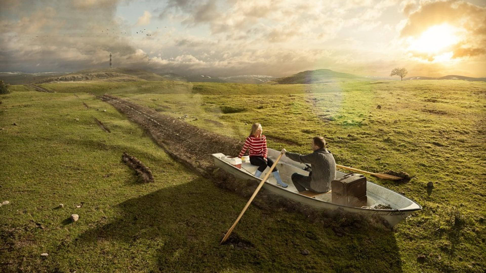 Rowing 桌布 壁紙 — 一對情侶划著小船穿越超現實的草地，背景是戲劇性的日落天空。