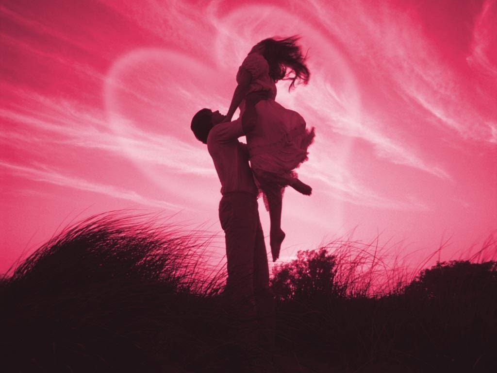 Cute Love 桌布 壁紙 — 一對情侶剪影映襯在充滿活力的粉紅色天空下，有心形狀的雲朵，男子開心地抱起女子。