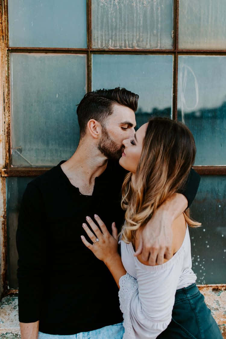 Beautiful Couple 桌布 壁紙 — 一對情侶在一個鏽蝕框架的風化藍色窗戶旁親密接吻。