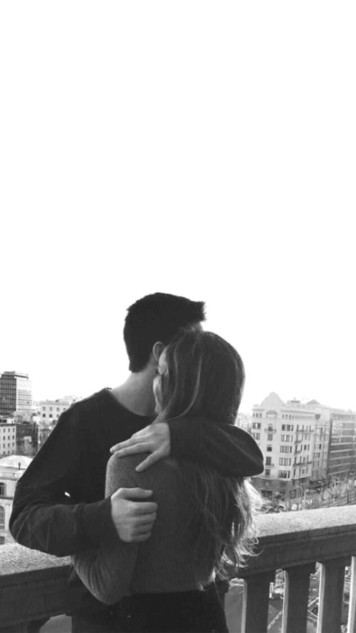 Lovers 桌布 壁紙 — 一對情侶在俯瞰城市景觀的陽台上擁抱的黑白照片。