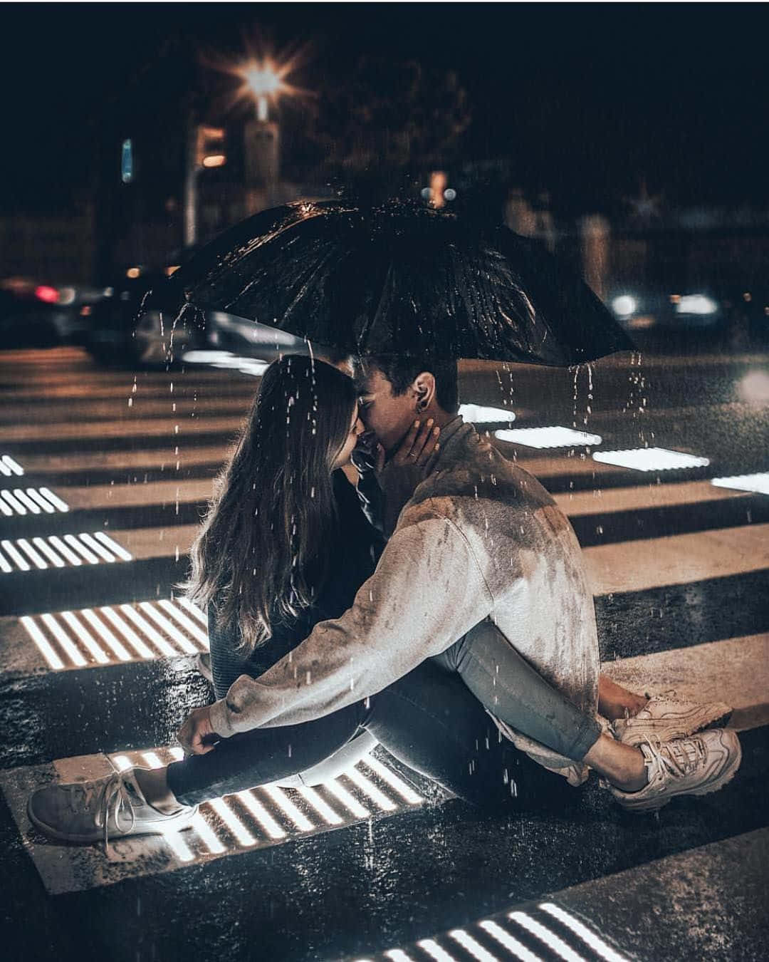Pedestrian 桌布 壁紙 — 一對情侶在夜間濕漉漉的城市行人穿越道，於黑色雨傘下親密接吻，雨正下著。