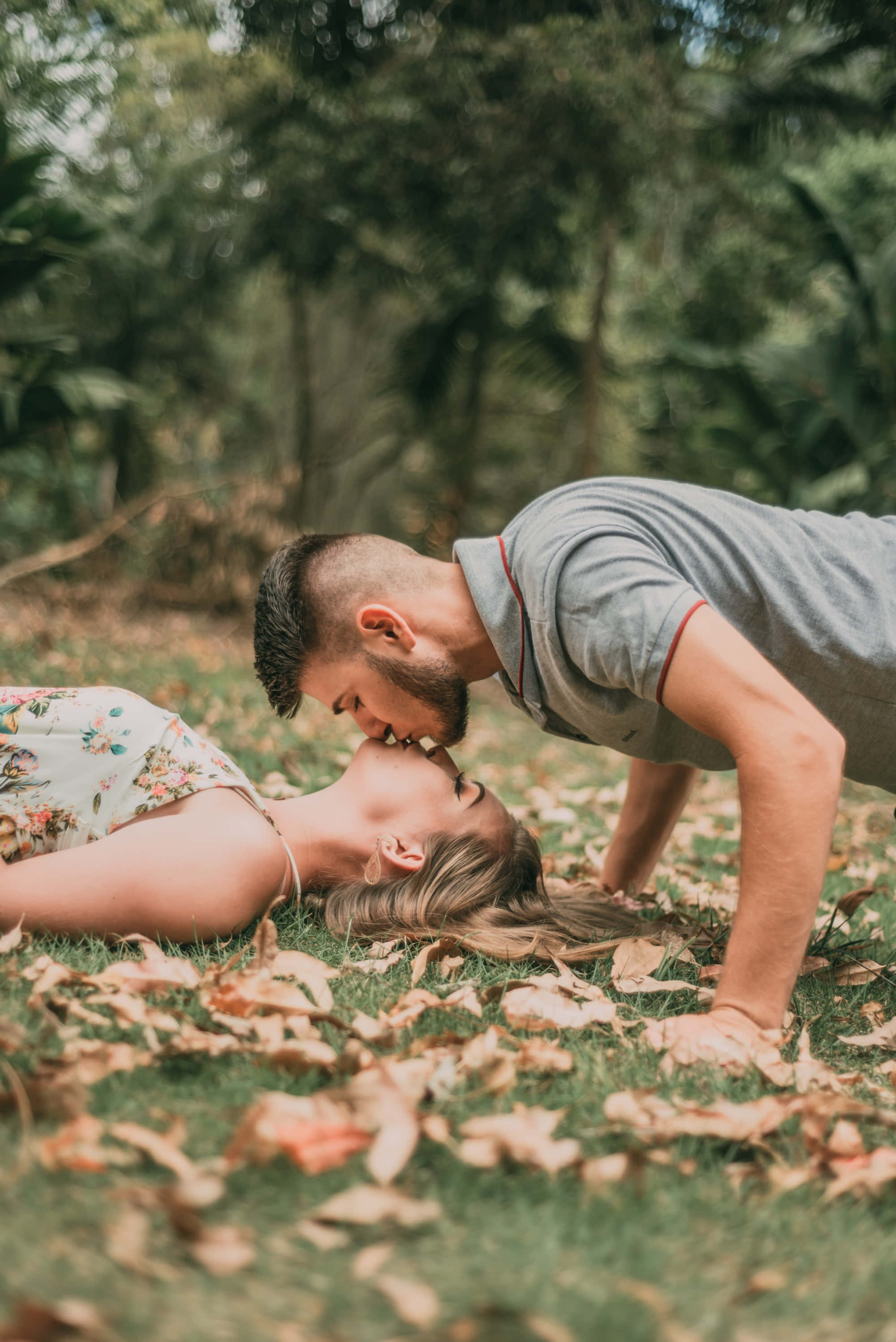 Kissing 桌布 壁紙 — 一對情侶在散落著秋葉的草地上親吻。