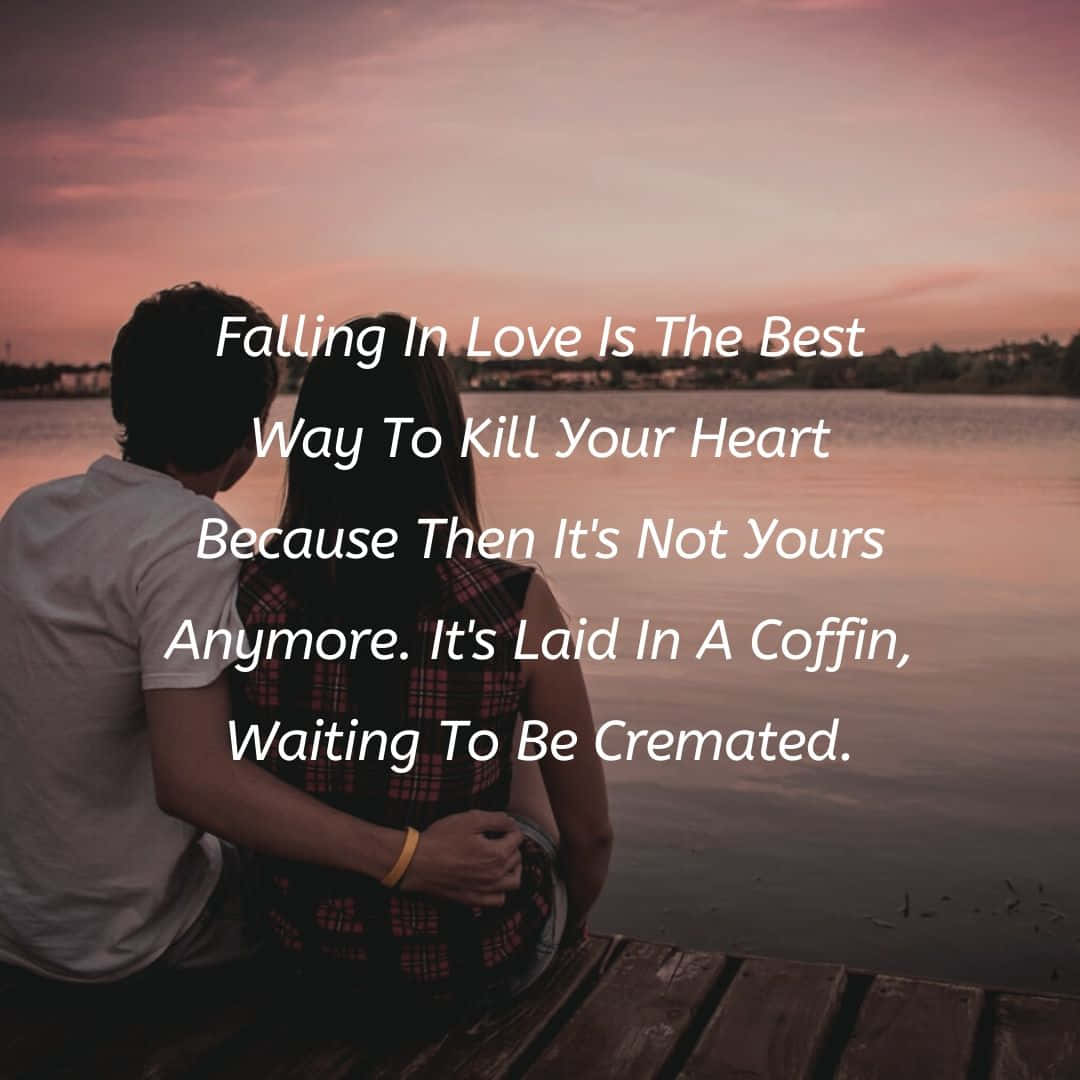 Falling In Love 桌布 壁紙 — 一對情侶在日落時分緊靠著坐在木製碼頭上，在平靜水面上粉紅色和橙色的天空映襯下形成剪影，並疊加了詩意文字。