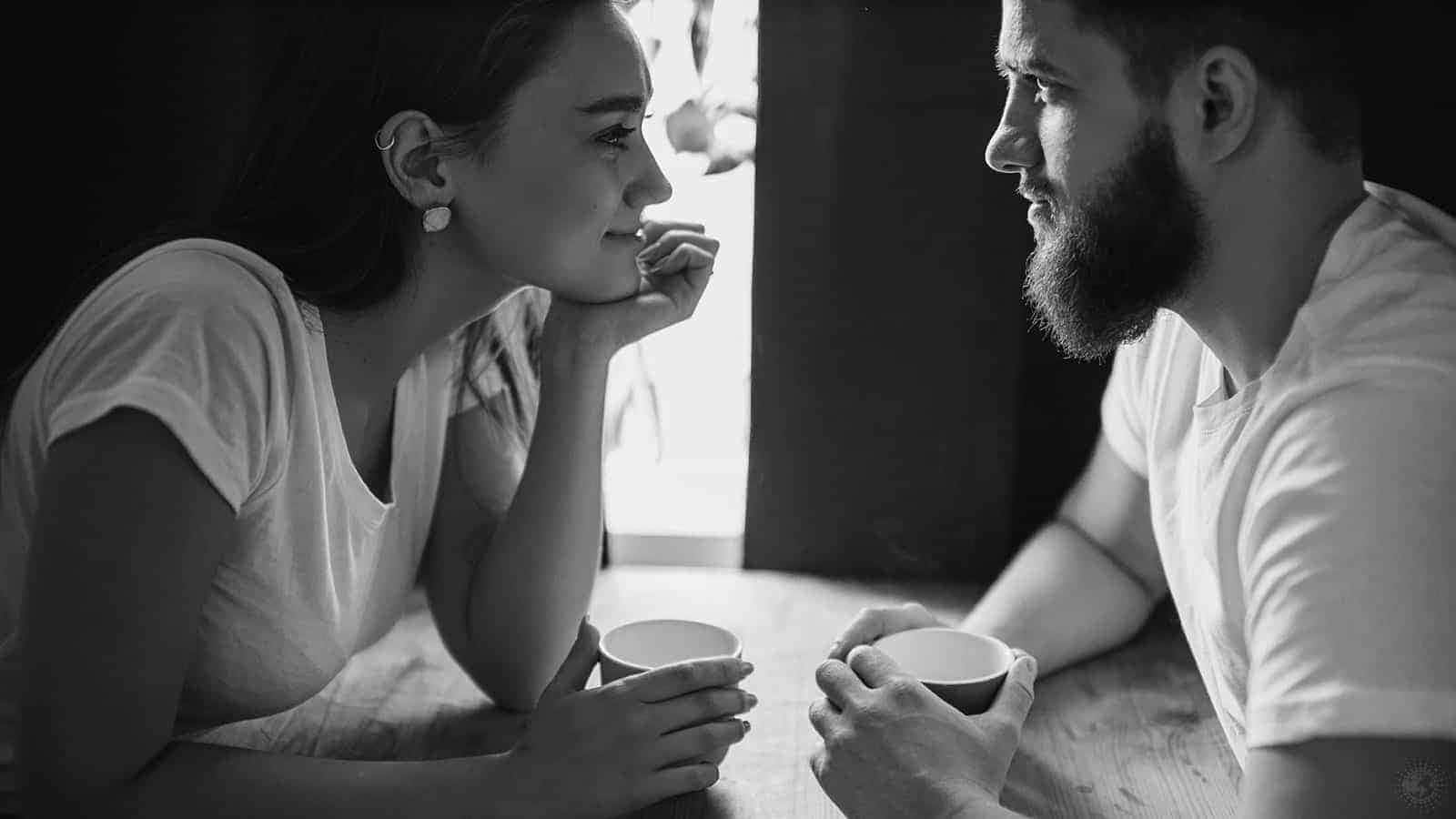 Falling In Love 桌布 壁紙 — 一對情侶在昏暗的咖啡館裡喝咖啡分享寧靜時刻的黑白親密肖像。