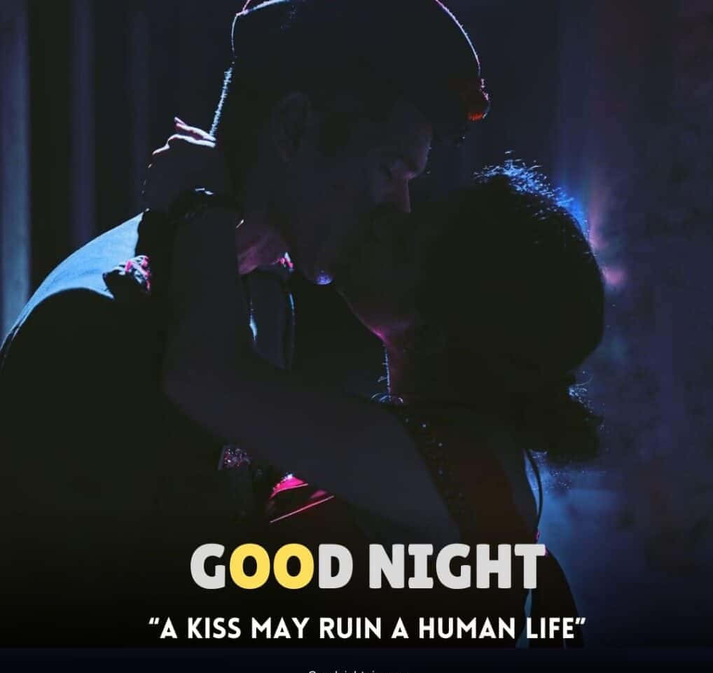 Goodnight Kiss 桌布 壁紙 — 一對情侶在昏暗的房間中擁抱，房間沐浴在紫色和藍色燈光中，並帶有文字疊加。