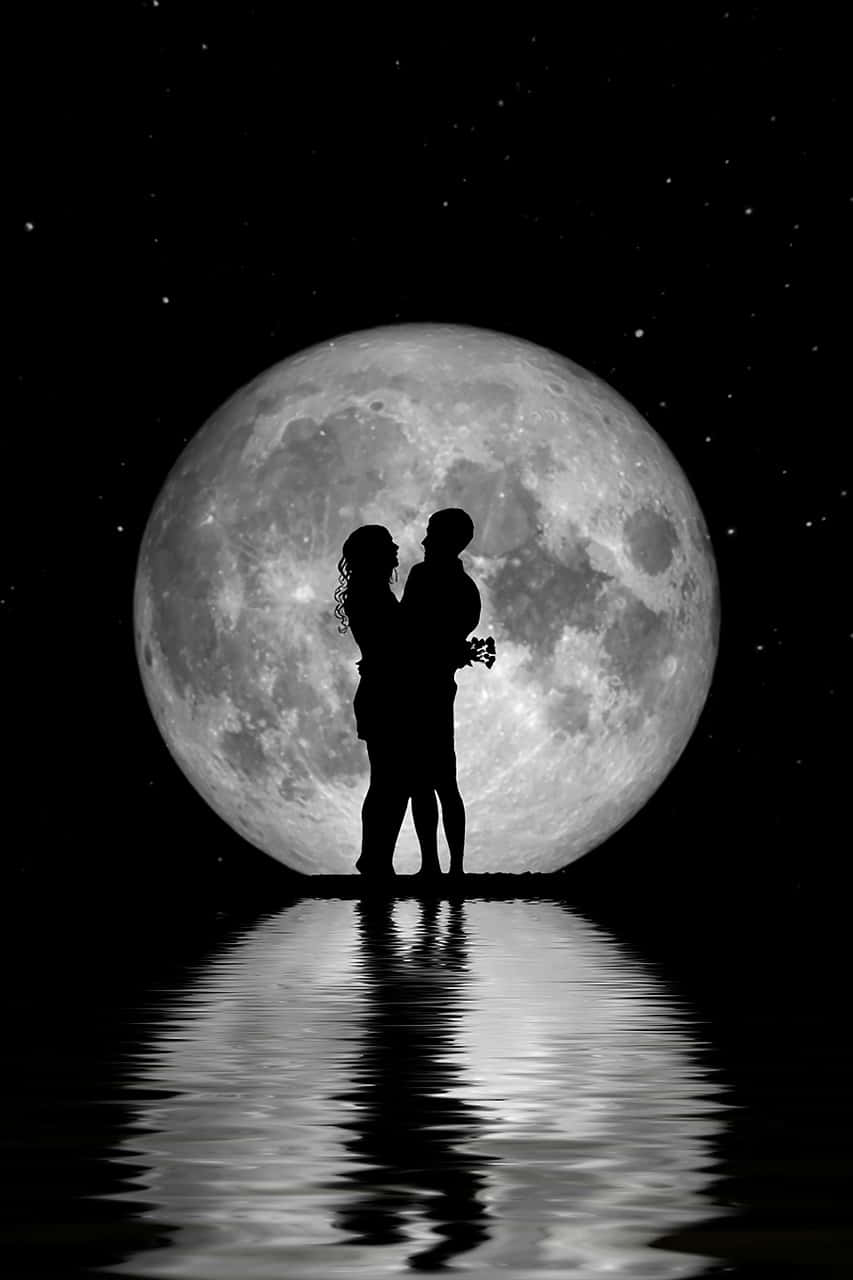 Moon Night 桌布 壁紙 — 一對情侶在星空下，於漣漪水面倒映的巨大月亮下擁抱的浪漫剪影。