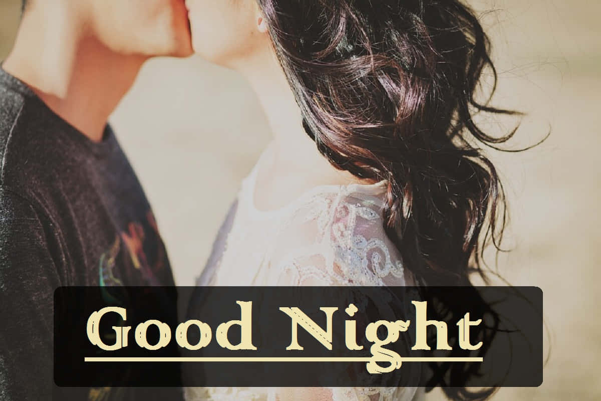 Goodnight Kiss 桌布 壁紙 — 一對情侶在柔和模糊的背景下，溫暖的金色光芒灑落在他們的側臉上，分享著親密的親吻。