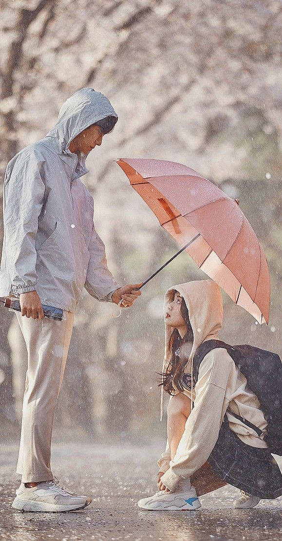 Couple 桌布 壁紙 — 一對情侶在模糊的櫻花中，於落雨下共享一把粉紅色雨傘。