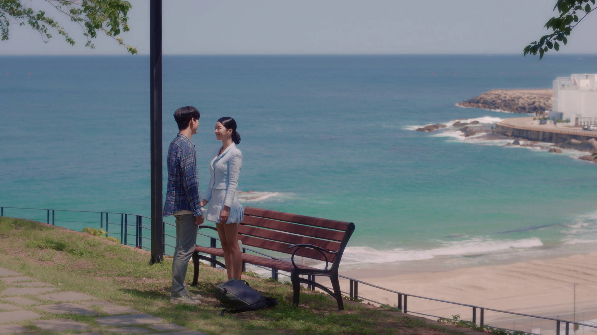 kdrama 桌布 壁紙 — 一對情侶在海邊懸崖小徑上面對面站立，下方有綠松石色的海浪拍打。