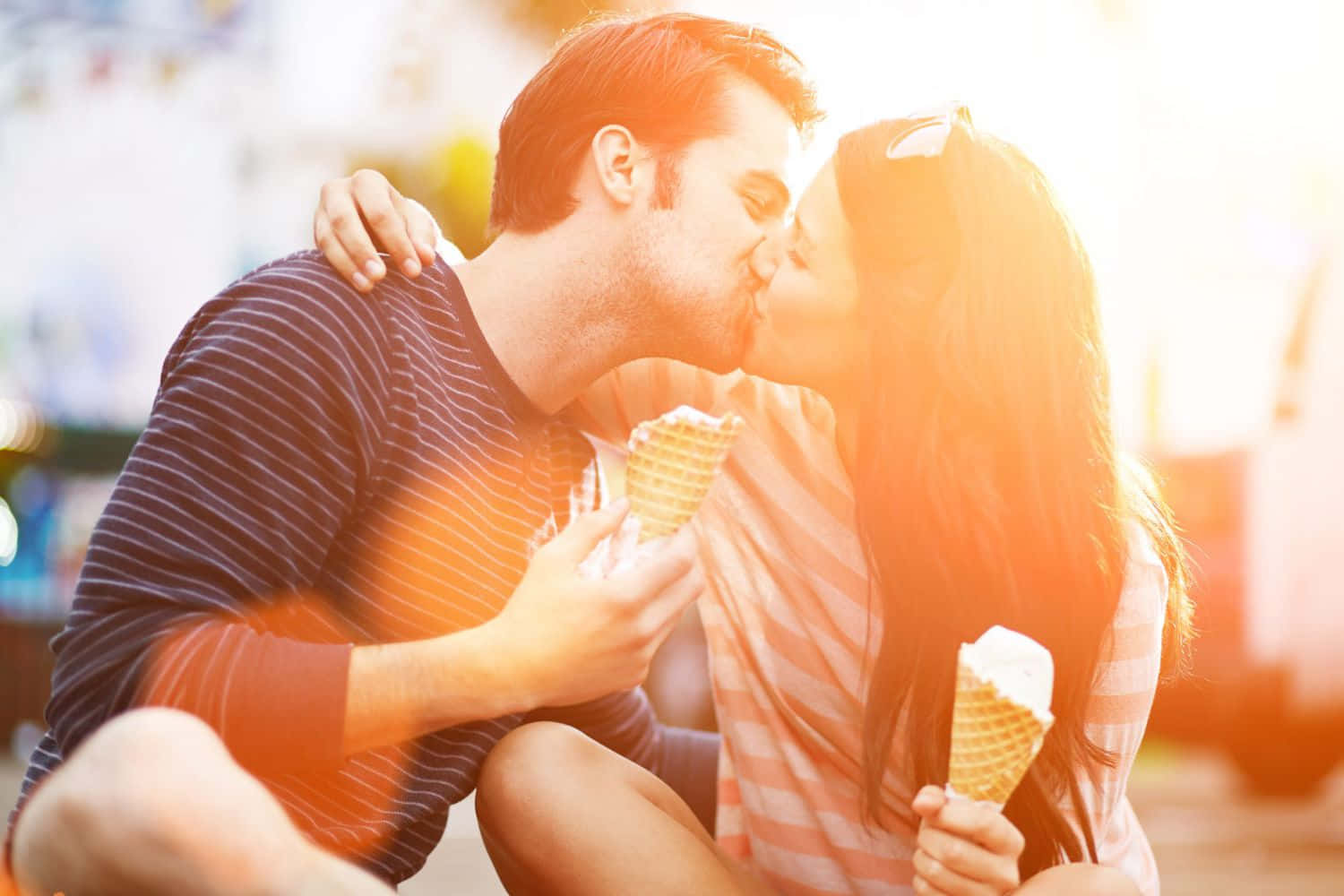 Romantic Love 桌布 壁紙 — 一對情侶在溫暖的金色陽光下，手持冰淇淋甜筒分享甜蜜一吻。