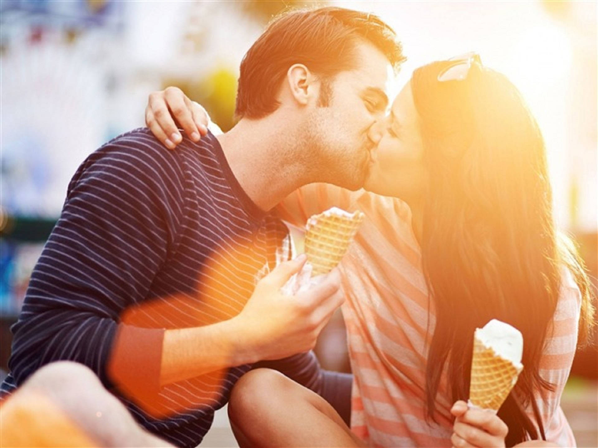 Romantic Love 桌布 壁紙 — 一對情侶在溫暖的金色陽光下，手持冰淇淋甜筒甜蜜接吻。