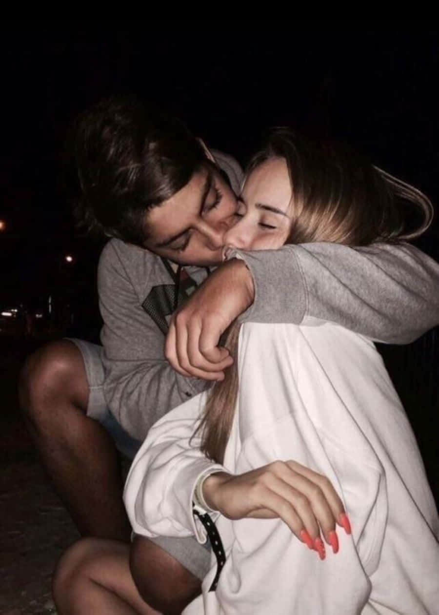 boyfriend 桌布 壁紙 — 一對情侶在漆黑的夜空下親吻，城市燈光在背景中隱約閃爍。