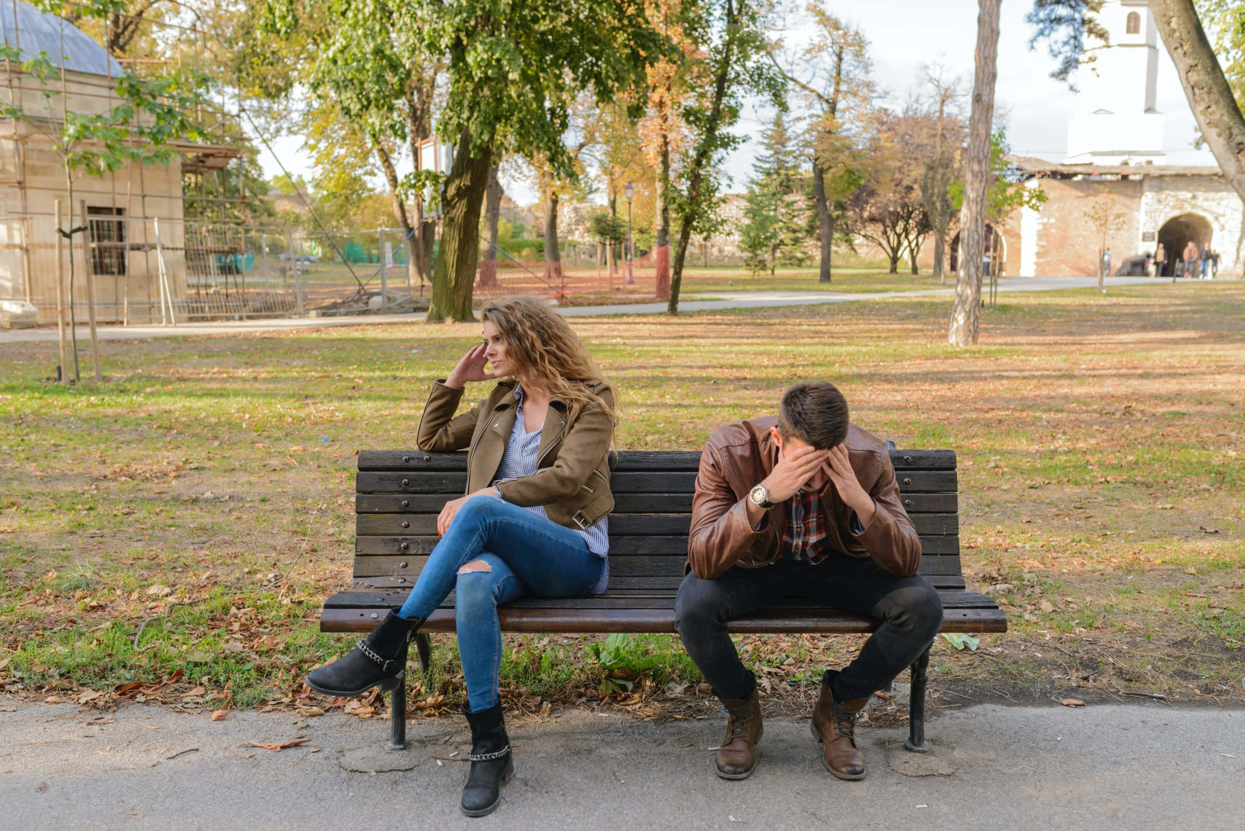 Break Up 桌布 壁紙 — 一對情侶在秋天分開坐在公園長椅上，女人望向別處，而男人痛苦地掩面。
