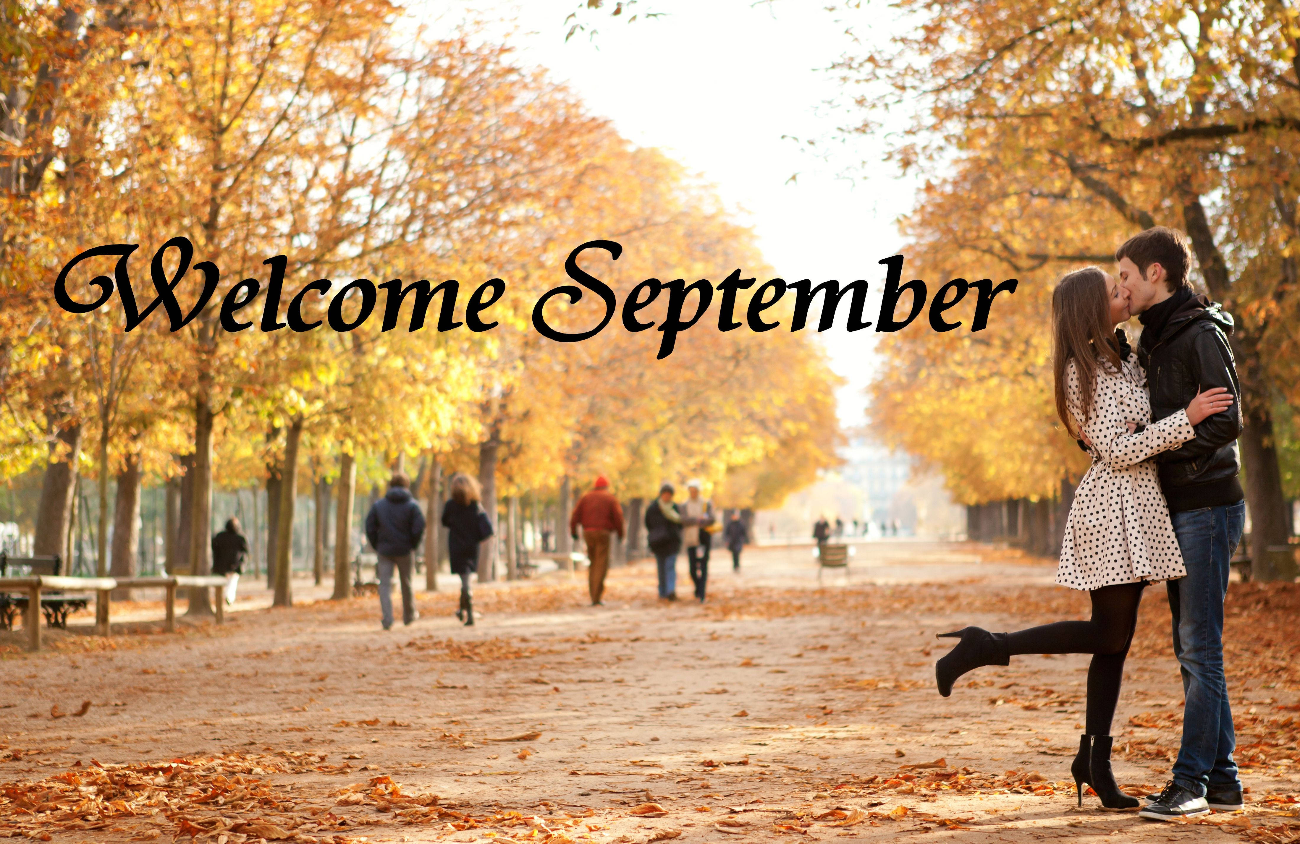 September 桌布 壁紙 — 一對情侶在金色秋樹下熱情接吻，落葉鋪滿他們身後的小徑。