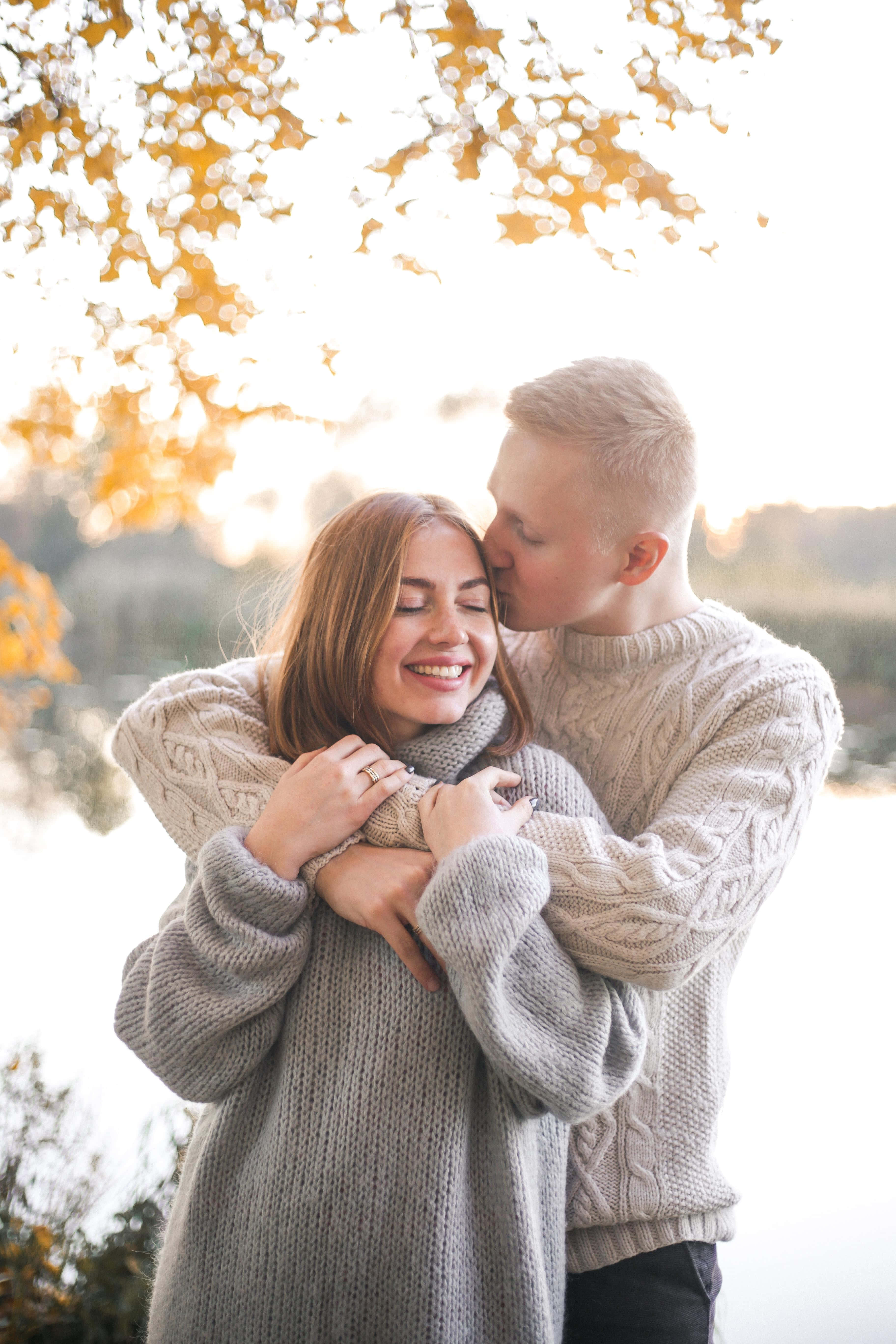 Forehead Kiss 桌布 壁紙 — 一對情侶在金黃色的秋葉下溫暖地擁抱，陽光穿過樹枝灑落。
