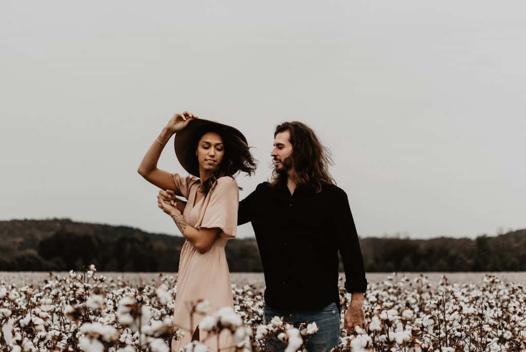Cotton Field 桌布 壁紙 — 一對情侶在陰天天空下穿過棉花田，色調柔和低調，互動溫柔。