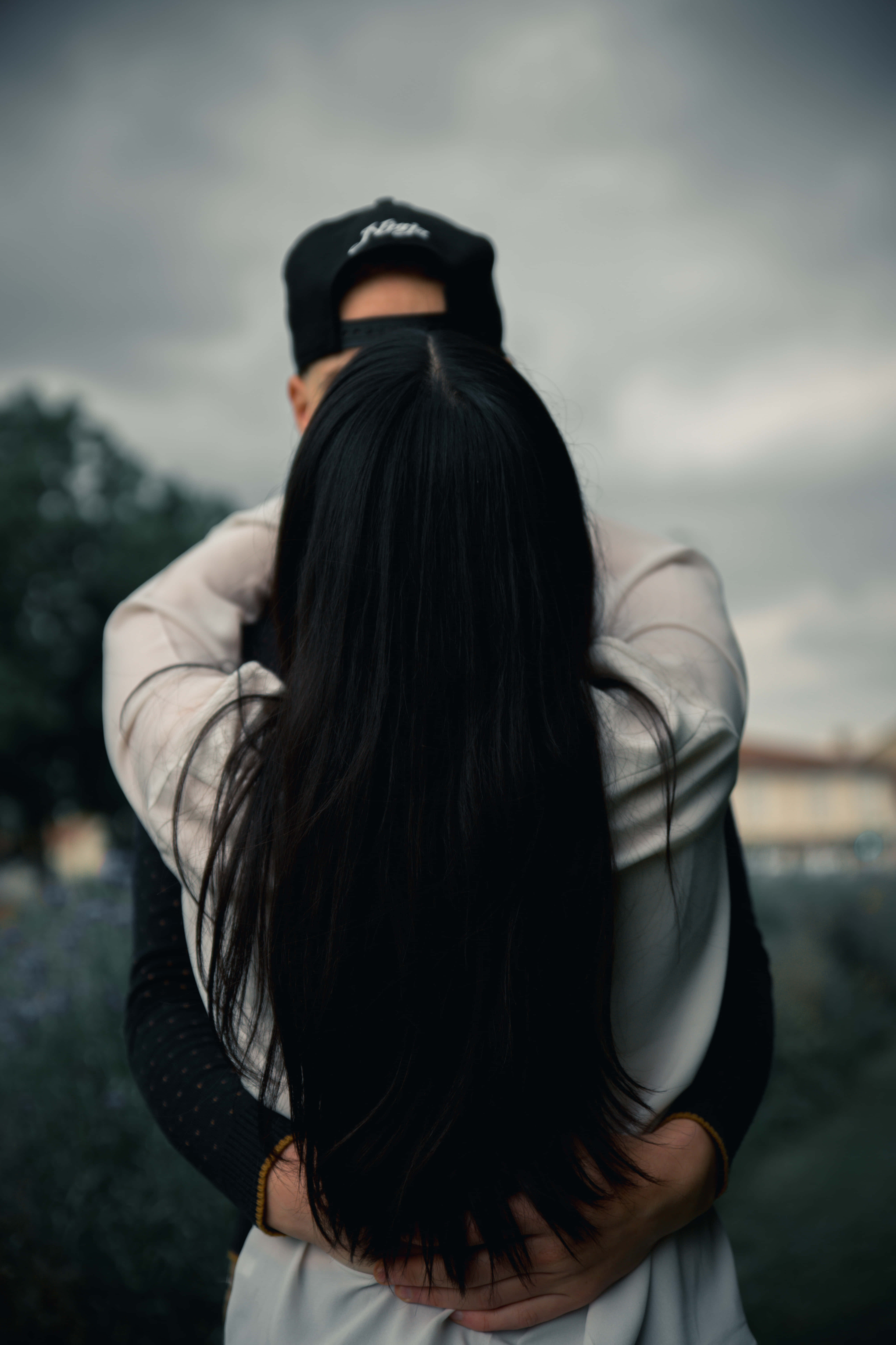 Lovers 桌布 壁紙 — 一對情侶在陰沉的灰色天空下從後擁抱，遠方有模糊的薰衣草田。