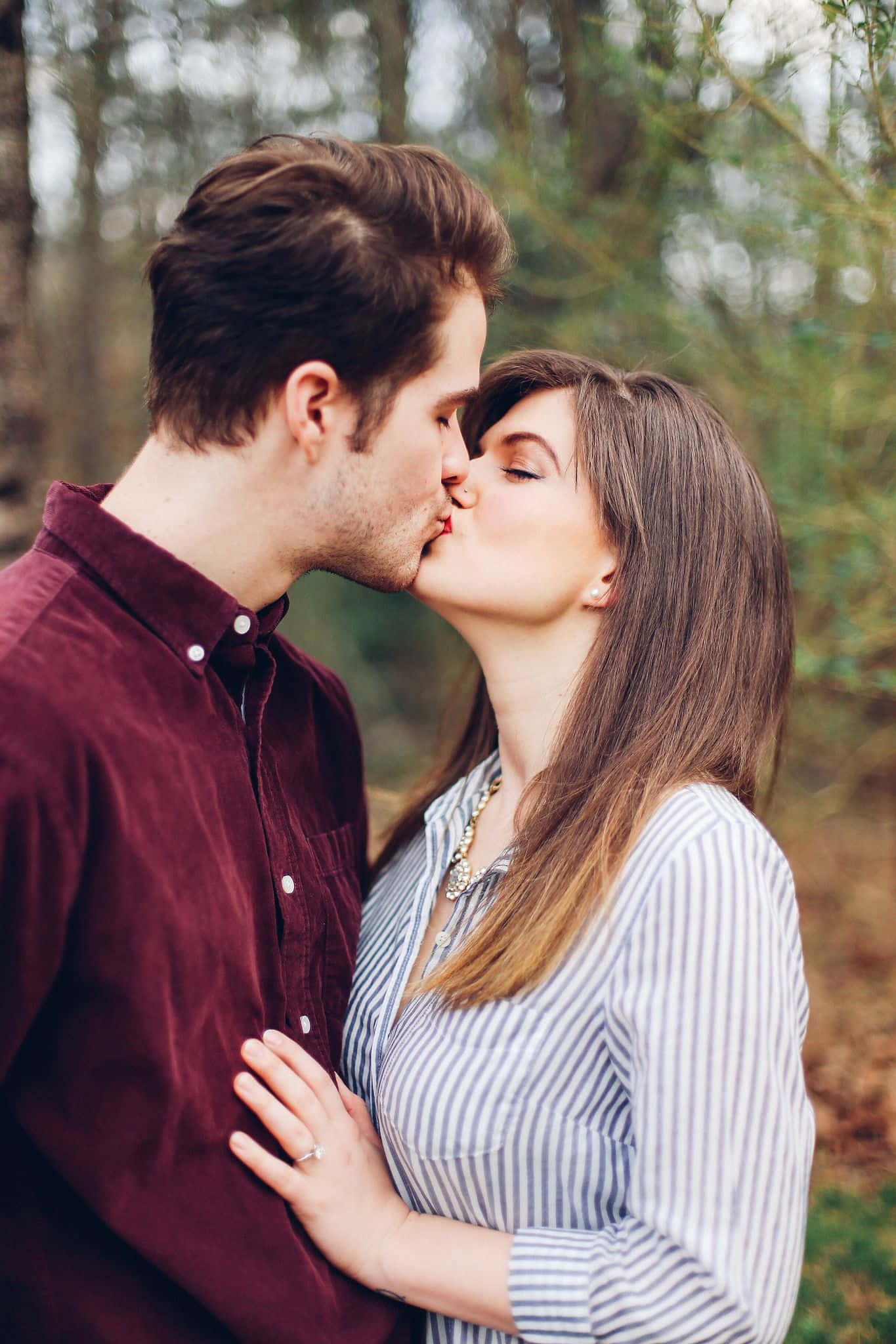 Kissing 桌布 壁紙 — 一對情侶在陽光普照的森林中親吻，背景帶有柔和散景效果。