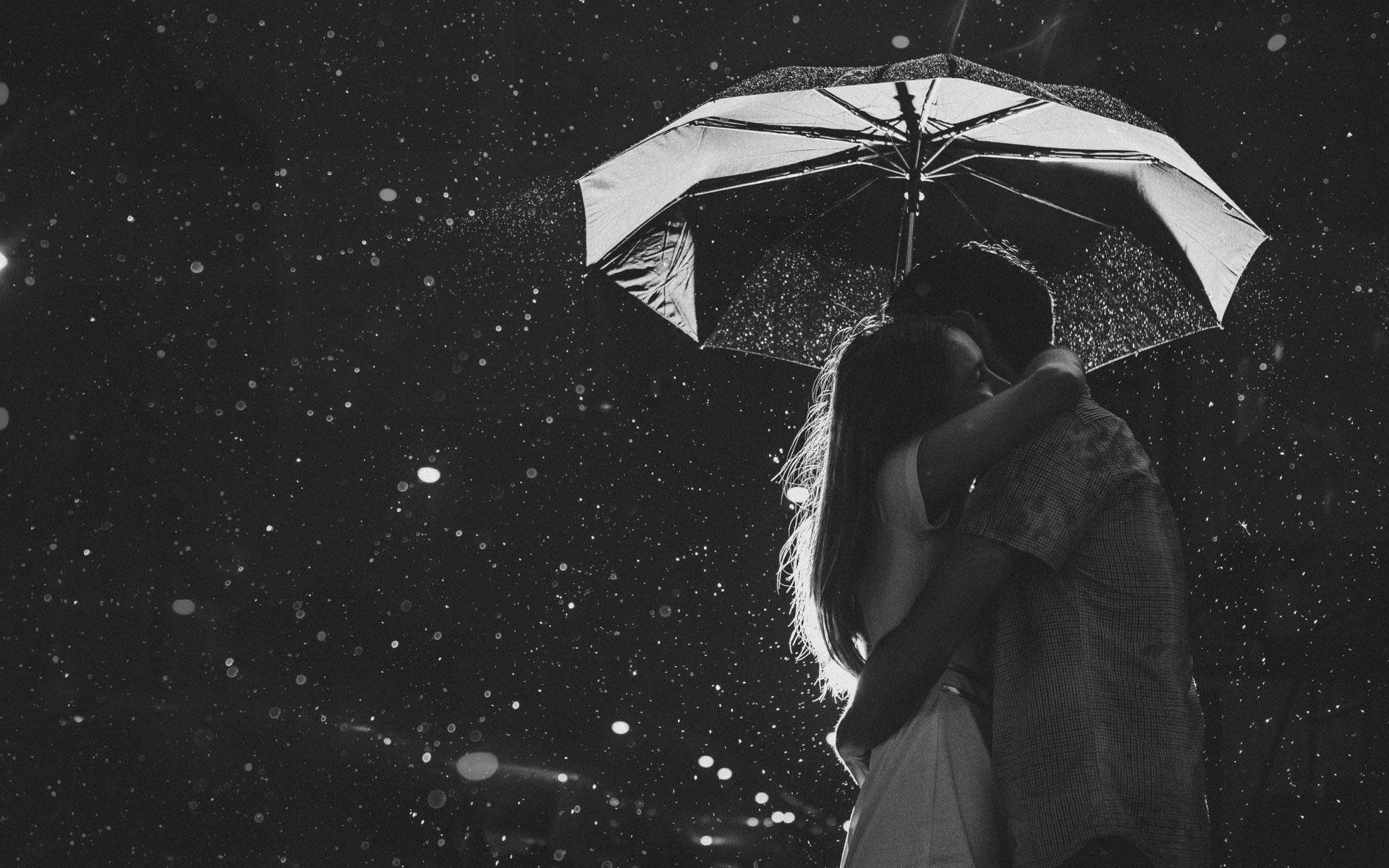 Lovers 桌布 壁紙 — 一對情侶在雨中共撐一把傘，相擁於充滿氛圍感的黑白場景中。