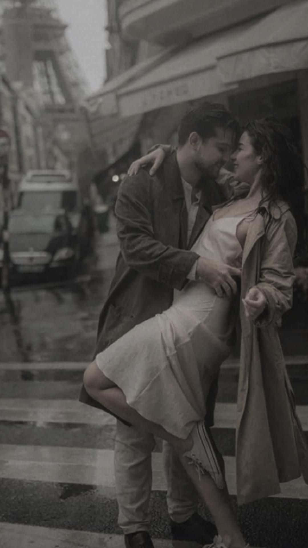 Hugging 桌布 壁紙 — 一對情侶在雨中的巴黎街頭，在柔和的黑白光影下親密擁抱。