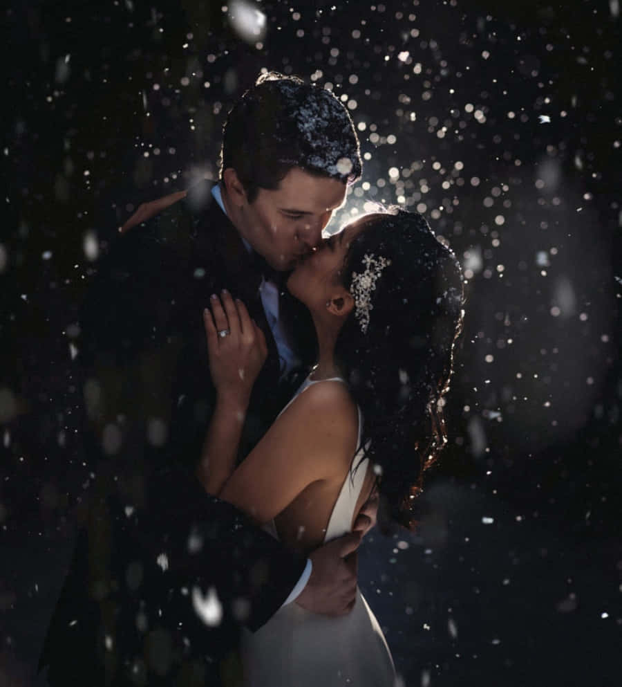 Kissing 桌布 壁紙 — 一對情侶在飄雪中親吻，柔和背光突顯他們的擁抱。