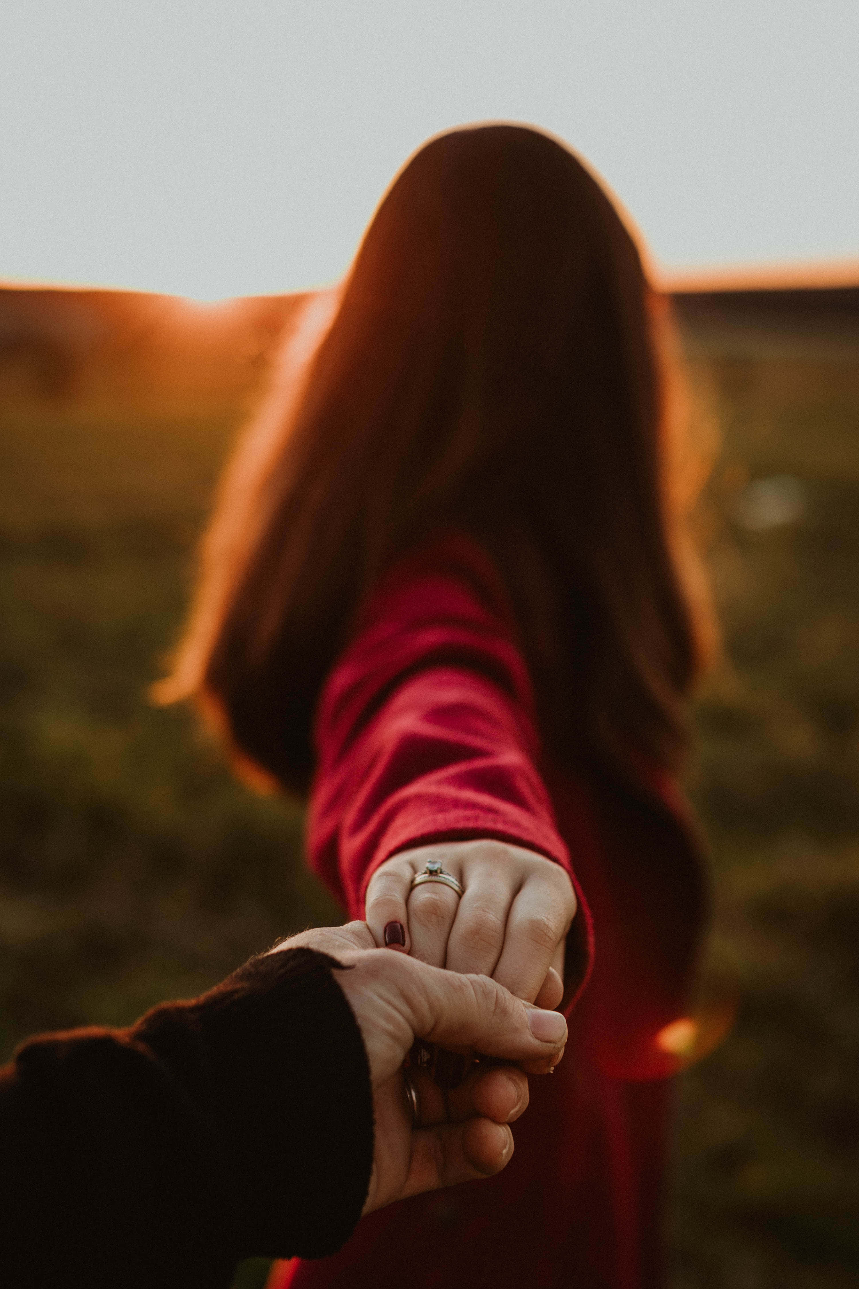 Holding Hands 桌布 壁紙 — 一對情侶從背後牽手，走過日落時分的金色田野。