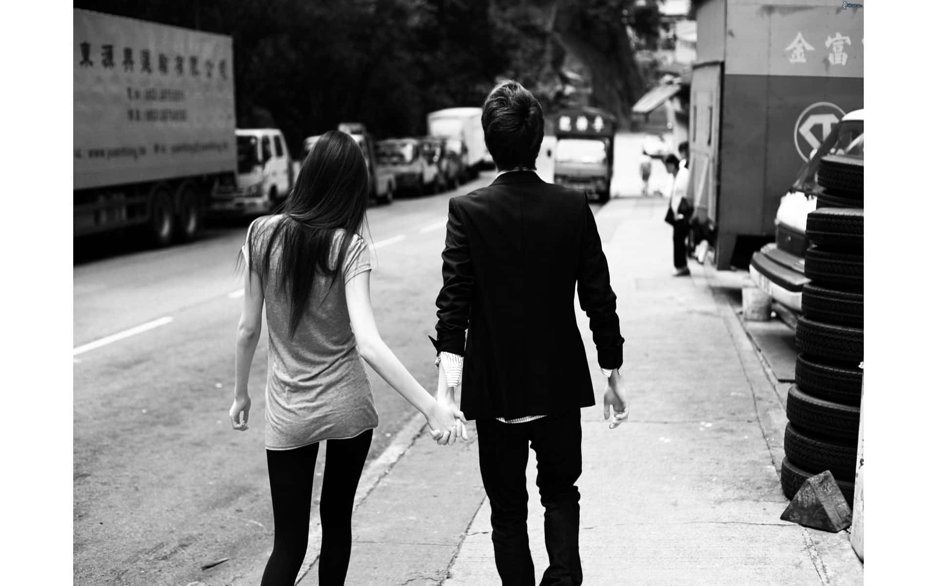 Relationship Cute Couple 桌布 壁紙 — 一對情侶手牽手沿著繁忙的城市人行道走開的黑白照片。