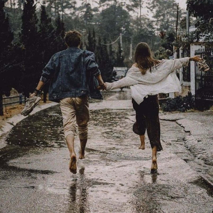 Aesthetic Couple 桌布 壁紙 — 一對情侶赤腳跑過被雨水浸濕的街道，手牽手，盡情歡樂。