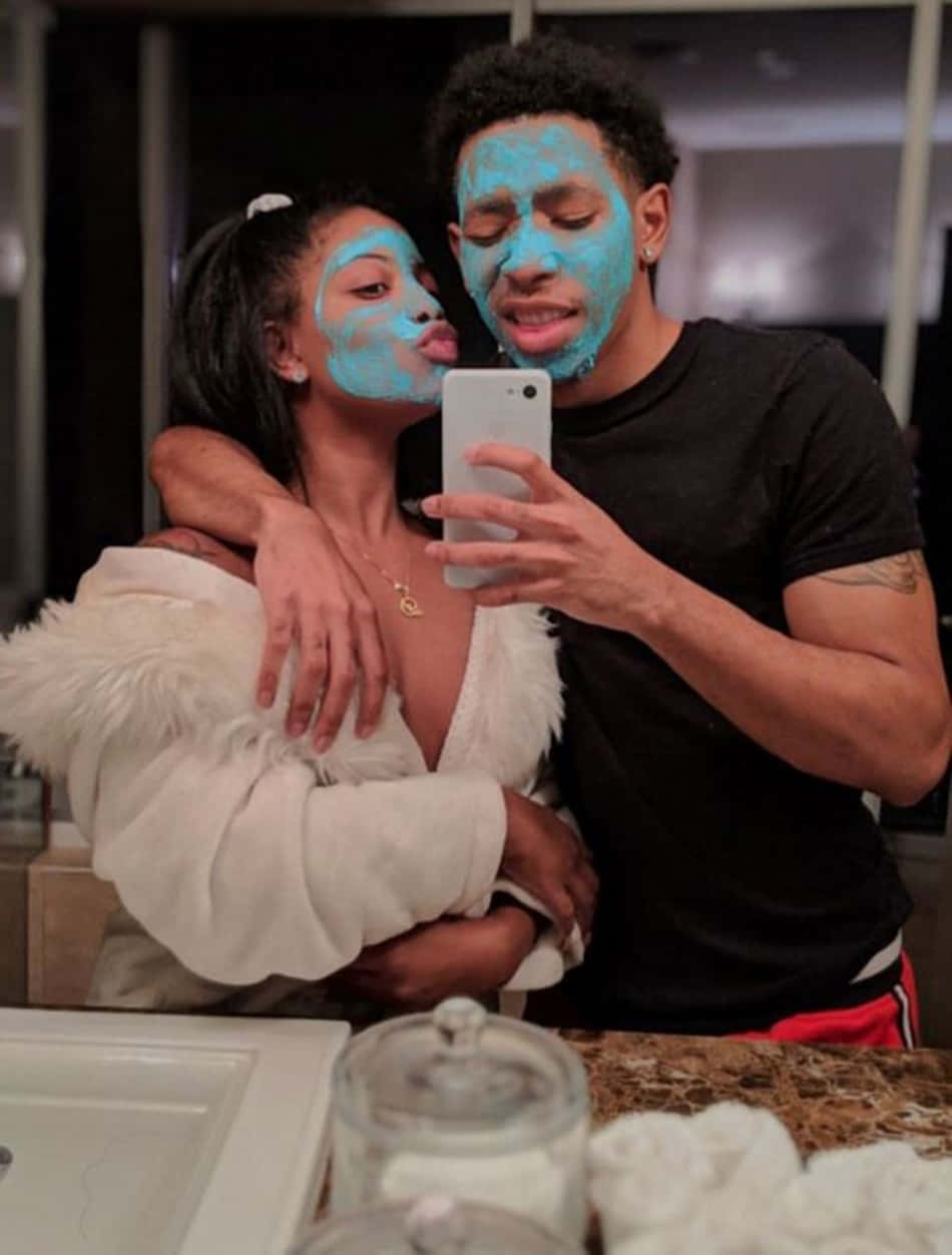 Freaky Couple 桌布 壁紙 — 一對戴著藍色口罩的情侶在浴室鏡前擁抱，並拍下一張俏皮的自拍照。