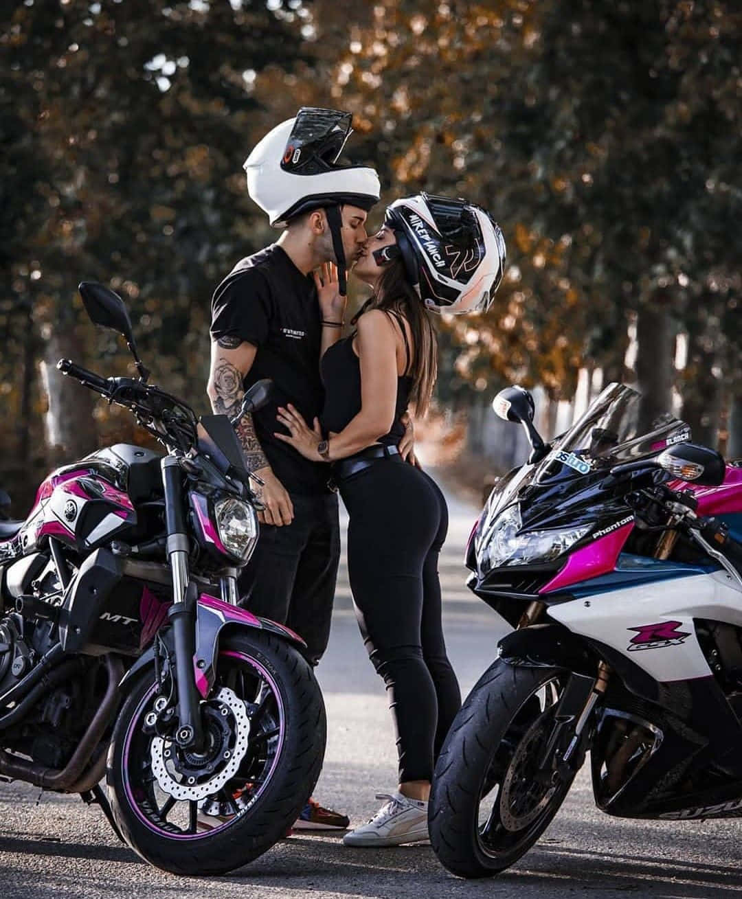 Lovers 桌布 壁紙 — 一對戴著頭盔的情侶在金色秋樹下，在兩輛運動機車旁熱情接吻。
