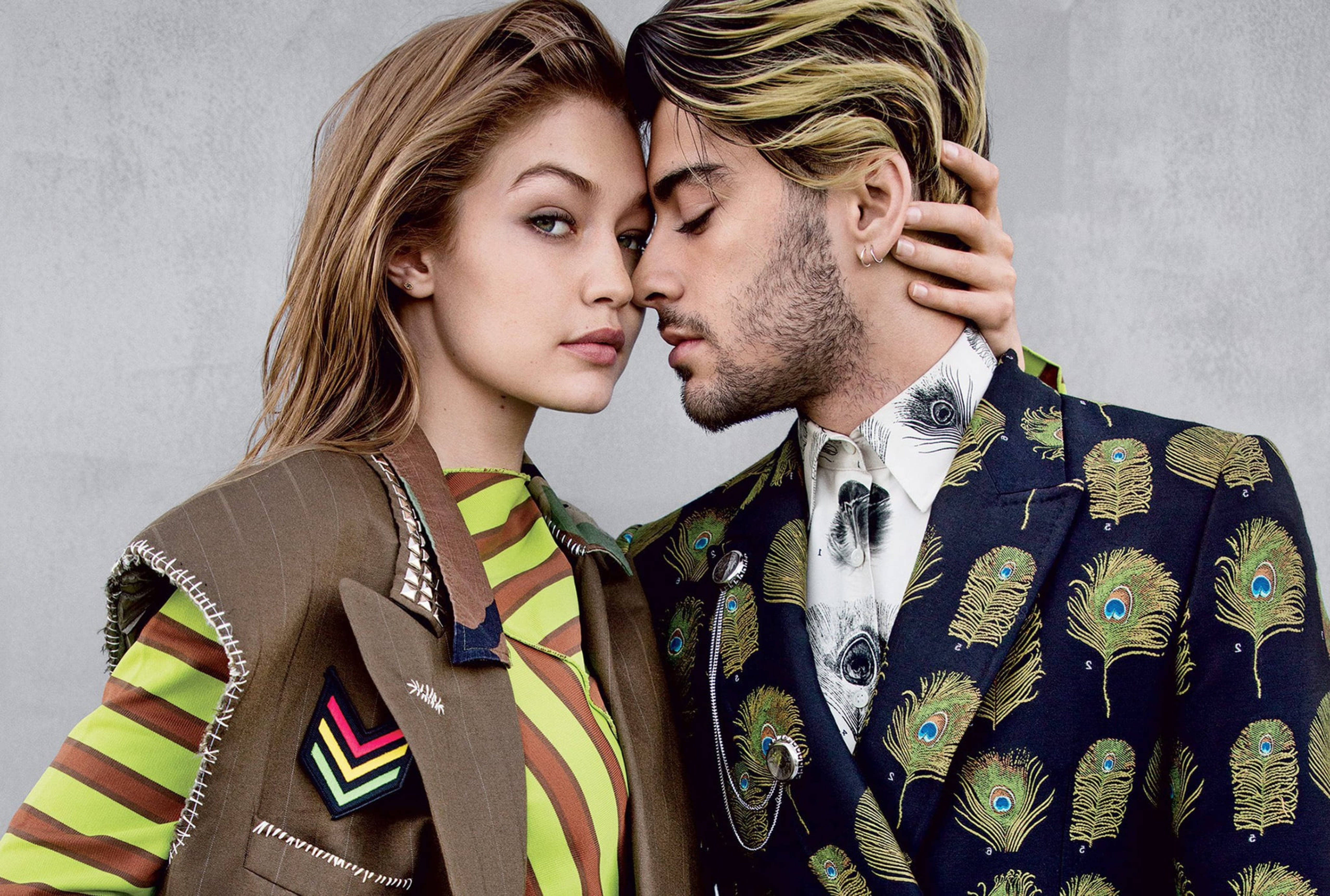 zayn 桌布 壁紙 — 一對時尚情侶穿著大膽圖案服裝，在紋理灰色牆壁前親密擺姿勢。