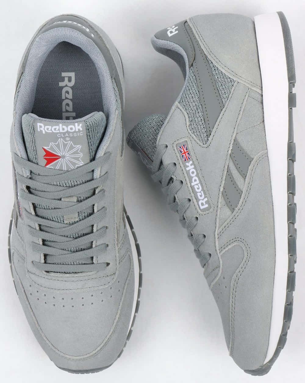 Reebok 桌布 壁紙 — 一對灰色 Reebok Classic 運動鞋，白色鞋底，帶有英國國旗品牌標誌，從頂部和側面展示。