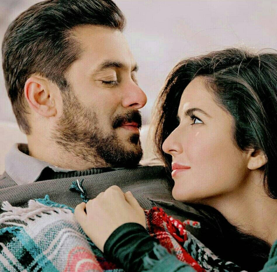 salman khan HD 桌布 壁紙 — 一對男女溫柔地近距離凝視對方，包裹在色彩繽紛的圖案毛毯中。
