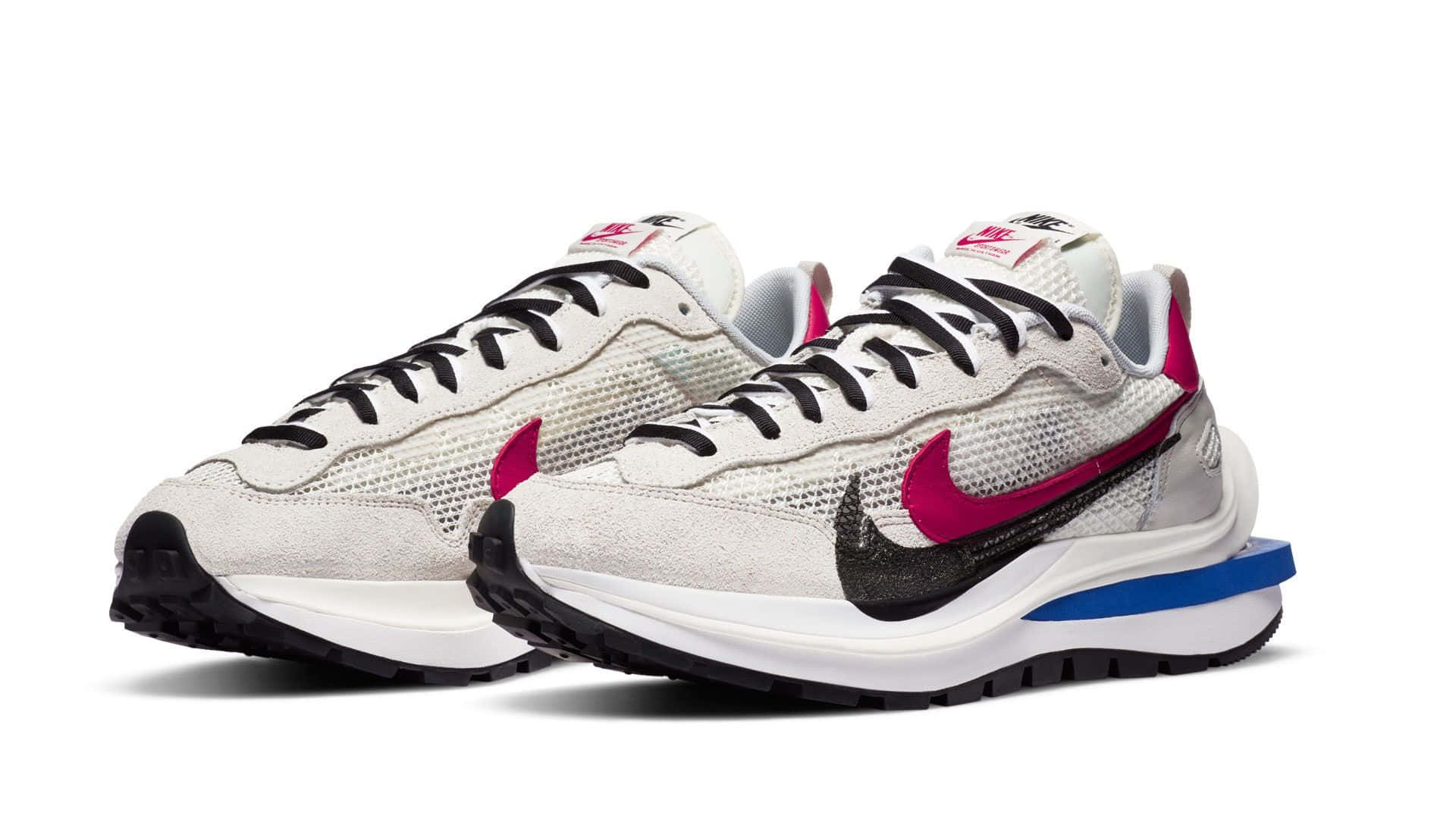 桌布 壁紙 — 一對白色Nike運動鞋，帶有洋紅色Swoosh標誌和藍色點綴，展示在純白色背景上。