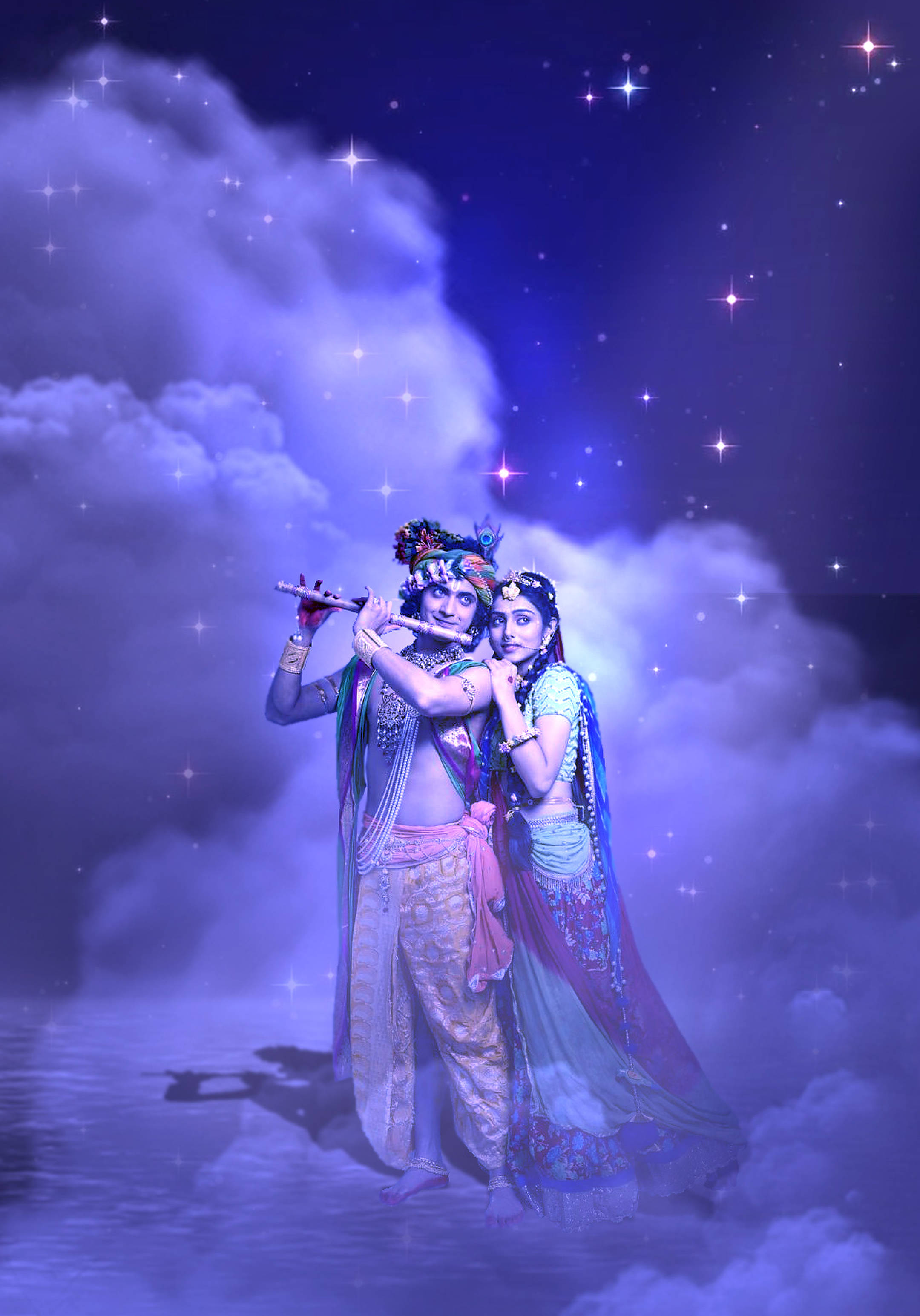 拉達克里希納 桌布 壁紙 — 一對神聖的夫婦穿著華麗的傳統服飾，站在雲端上，背景是繁星點點的紫色天空，一人吹奏笛子，另一人仰望天空。