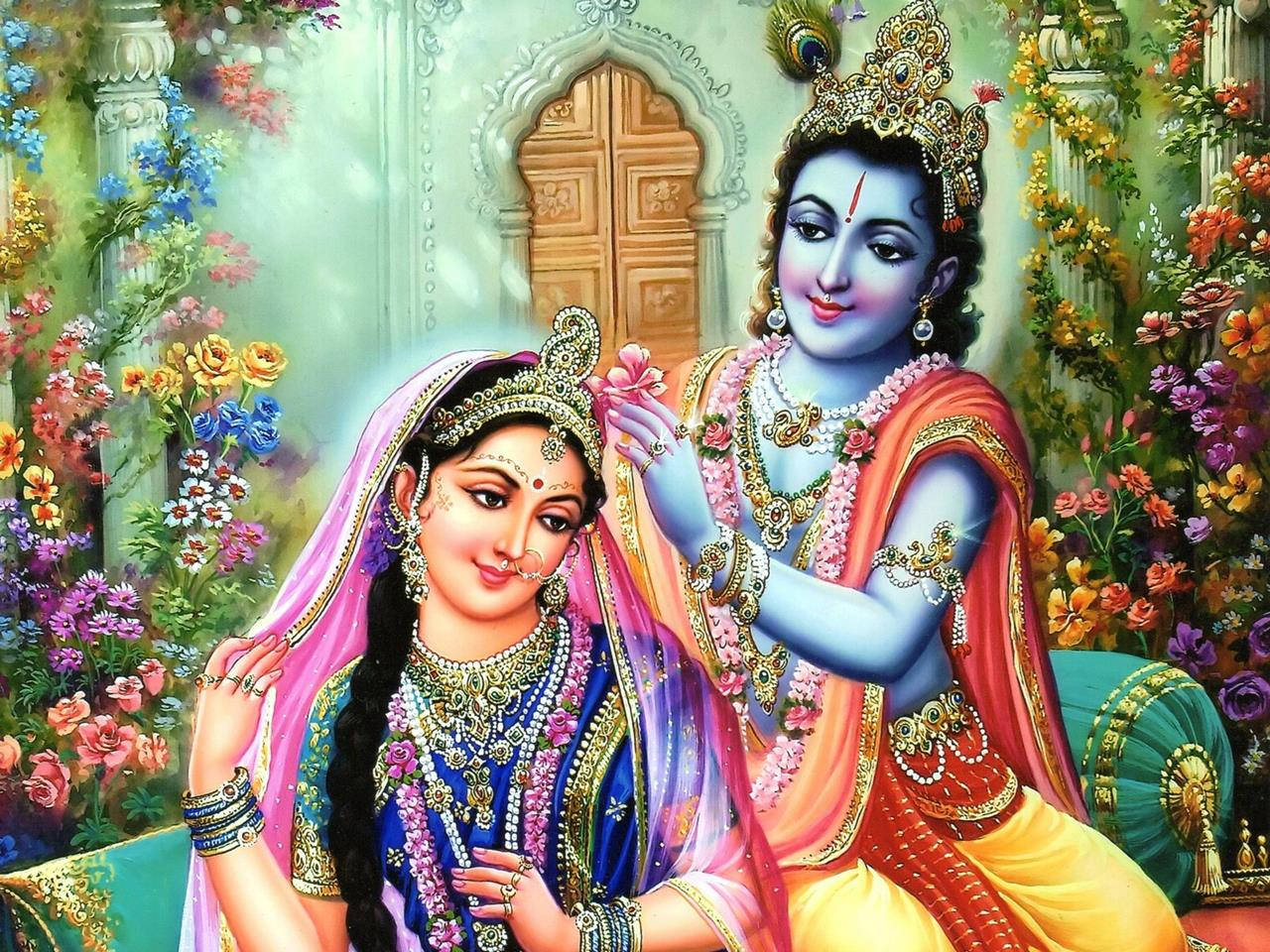 krishna bhagwan 桌布 壁紙 — 一對神聖的夫婦裝飾著華麗的珠寶和鮮豔的服飾，坐在柔光下色彩繽紛的花卉茂盛花園中。