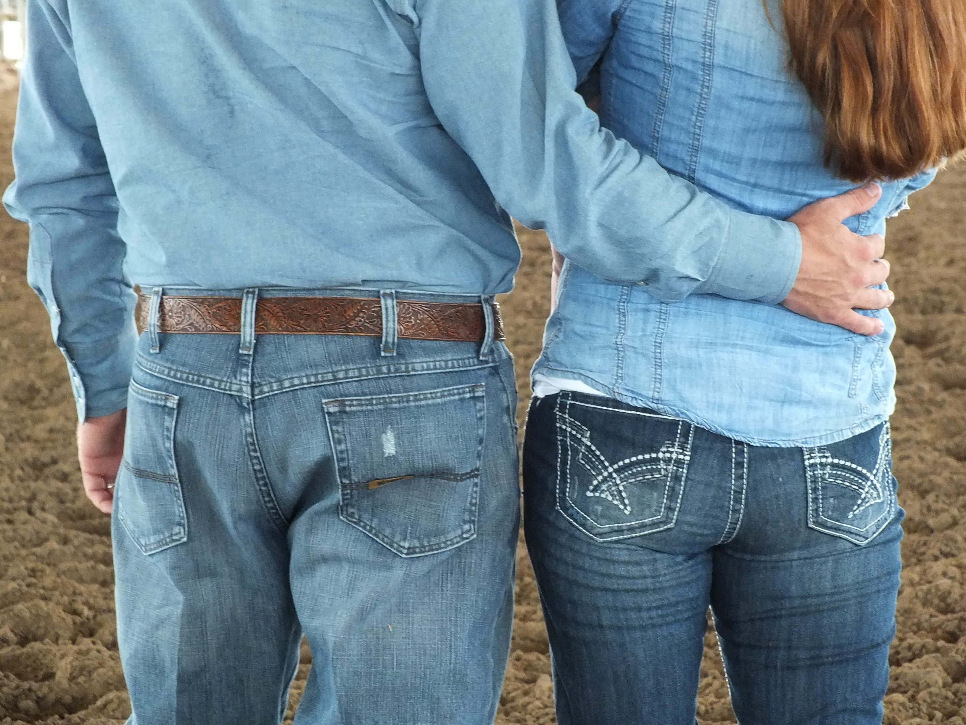 Country Couple 桌布 壁紙 — 一對穿著牛仔布的情侶在泥地上從後擁抱，男人的手放在女人的腰上。