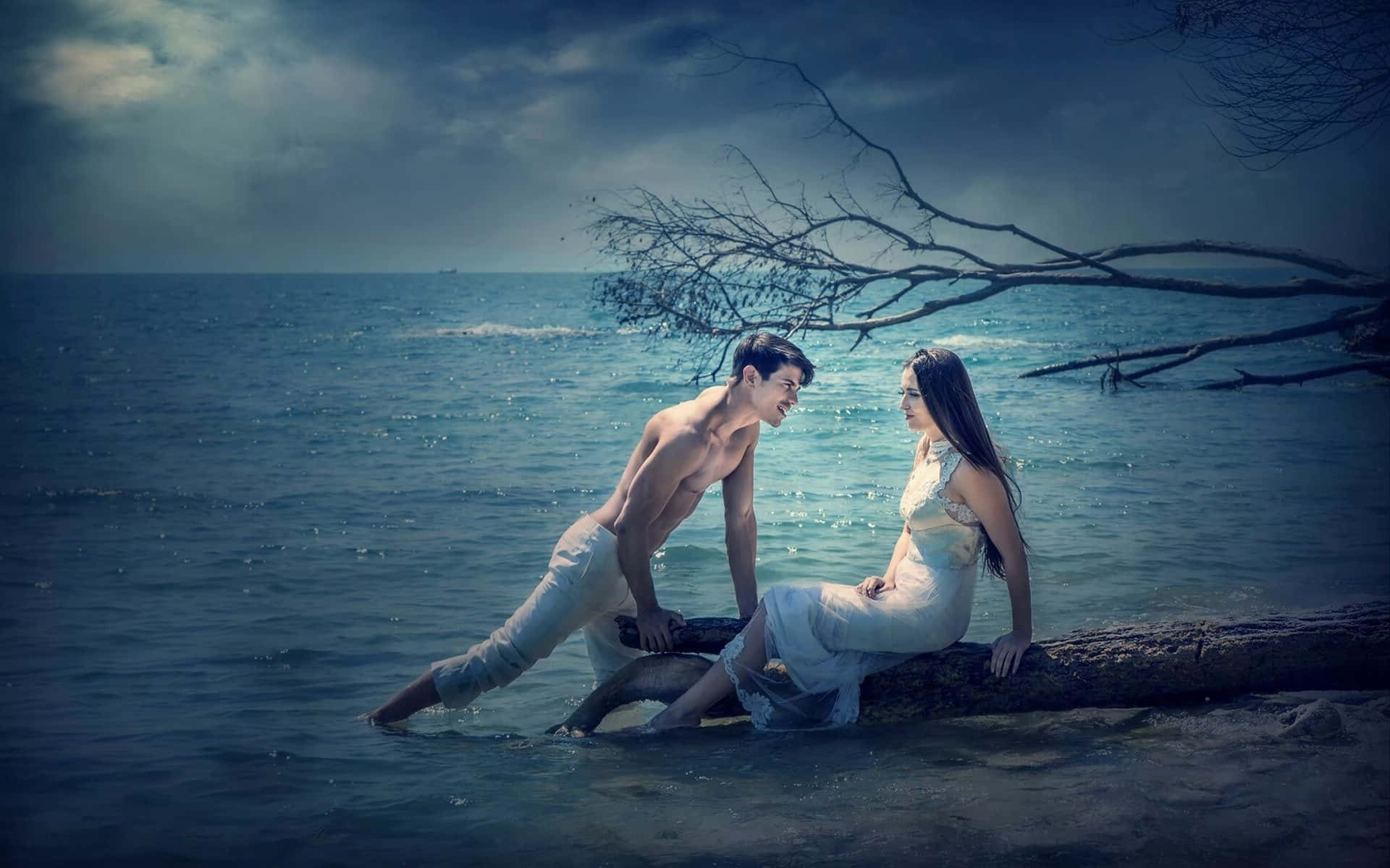 Romantic Love 桌布 壁紙 — 一對穿著白色禮服和短褲的情侶，在黑暗天空下的暴風雨海洋中的一根木頭上分享親密時刻。