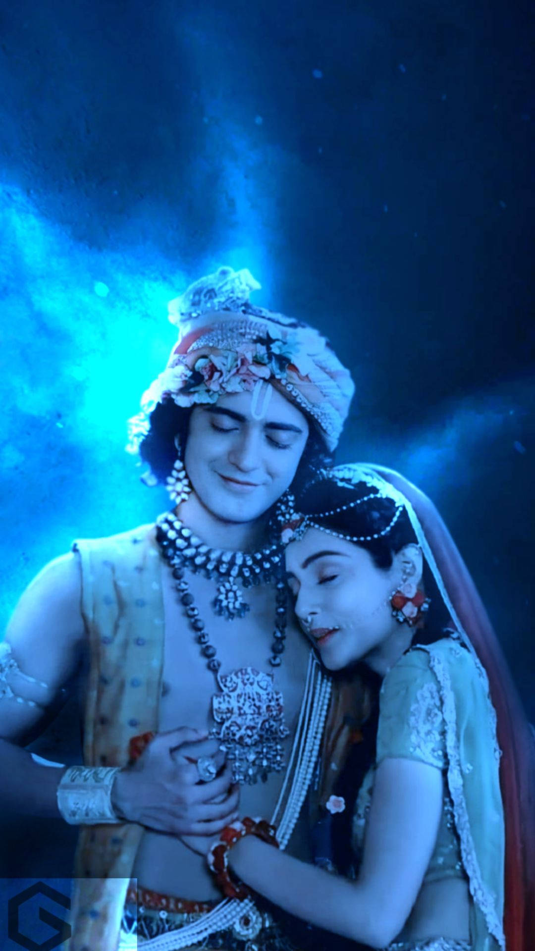 radha krishna serial 桌布 壁紙 — 一對穿著華麗傳統服飾的情侶，在閃爍的藍色空靈燈光下溫柔擁抱。