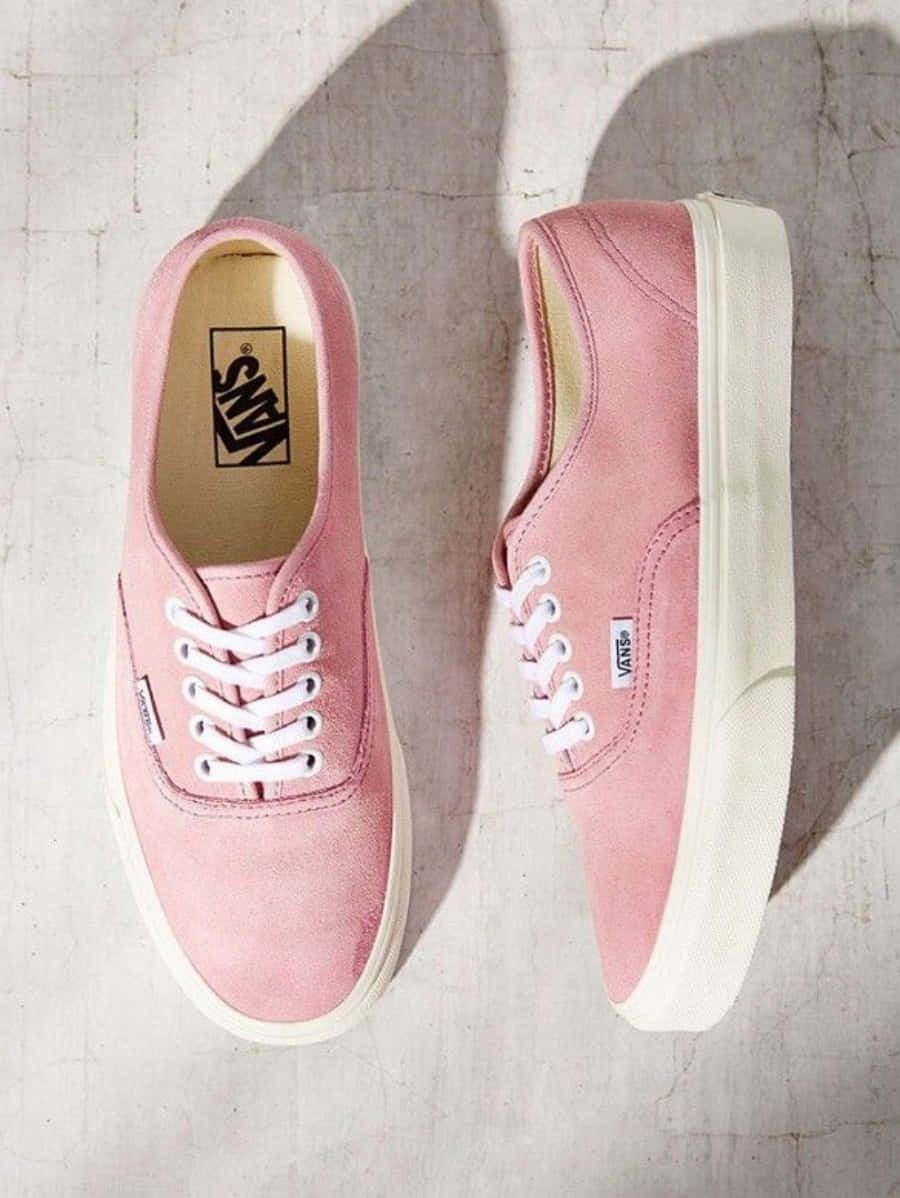 Pink Shoes 桌布 壁紙 — 一對粉紅色麂皮Vans運動鞋，搭配白色鞋帶和鞋底，在柔和燈光下放置在紋理混凝土表面上。