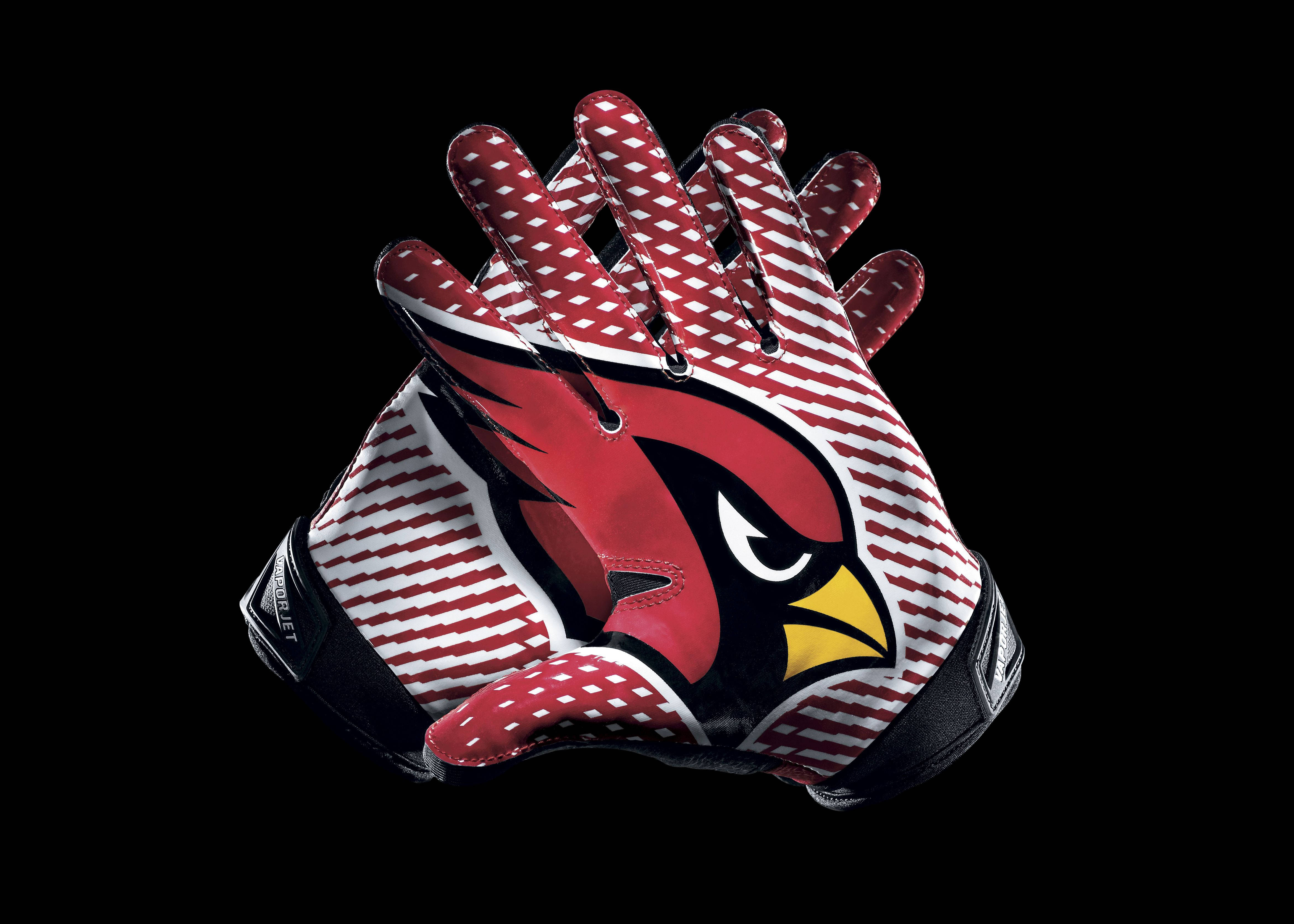 Cardinals 桌布 壁紙 — 一對紅白黑色的亞利桑那紅雀隊美式足球手套，隊徽展示在純黑背景上。