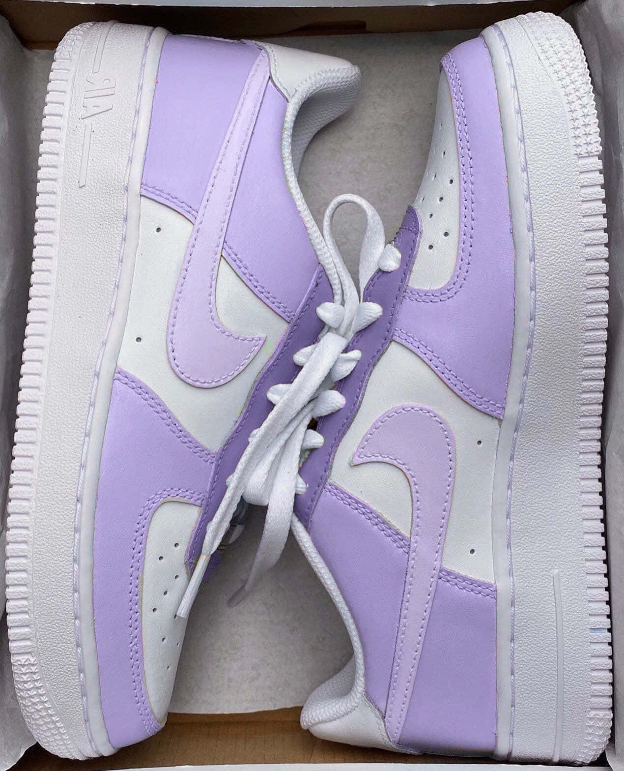 Nike Air Force 桌布 壁紙 — 一對薰衣草紫和白色的Nike Air Force 1運動鞋整齊地放在打開的紙板箱內。