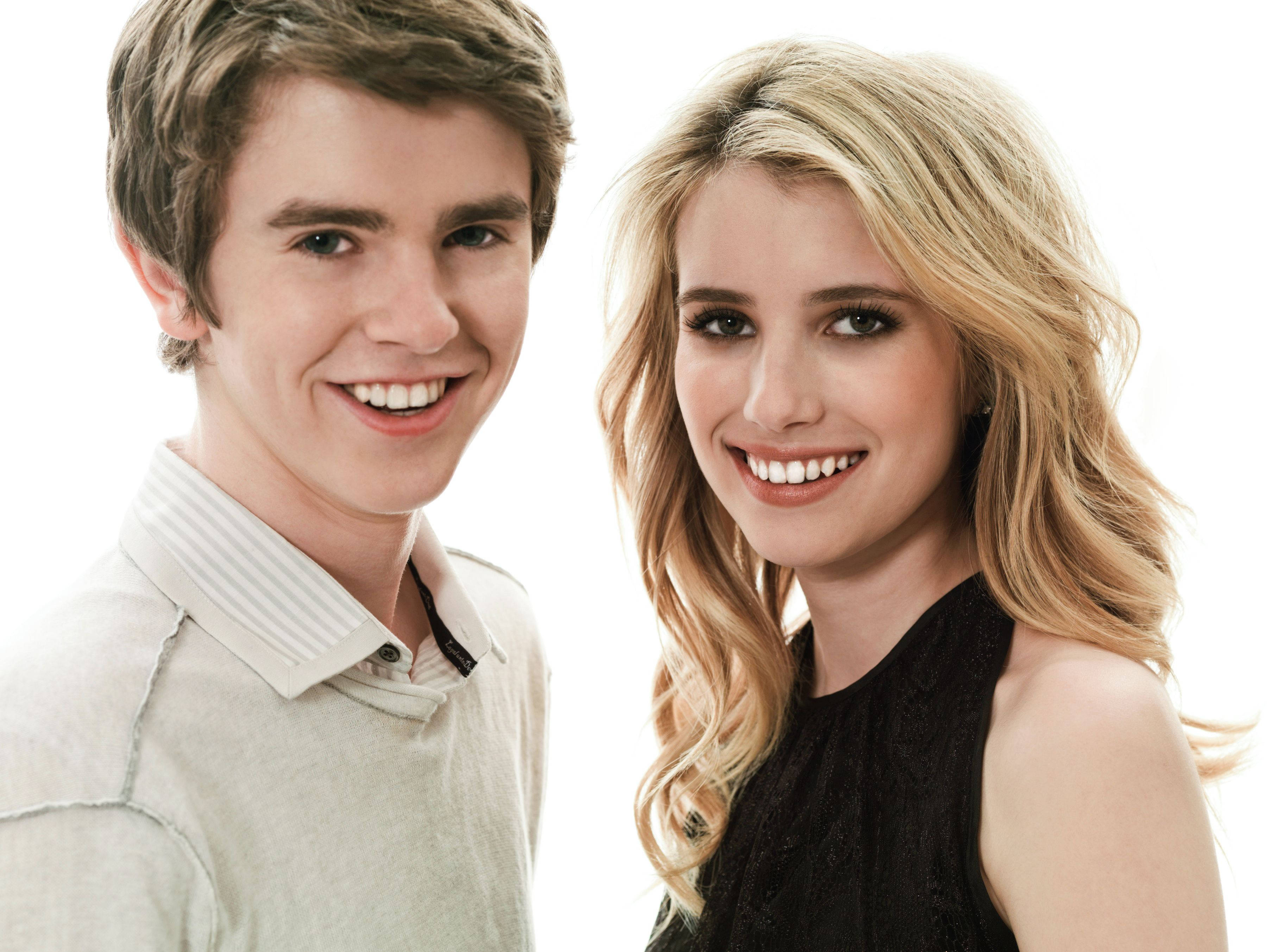 Freddie Highmore 桌布 壁紙 — 一對開朗的年輕男女在乾淨的白色背景前，於攝影棚肖像中燦爛微笑。