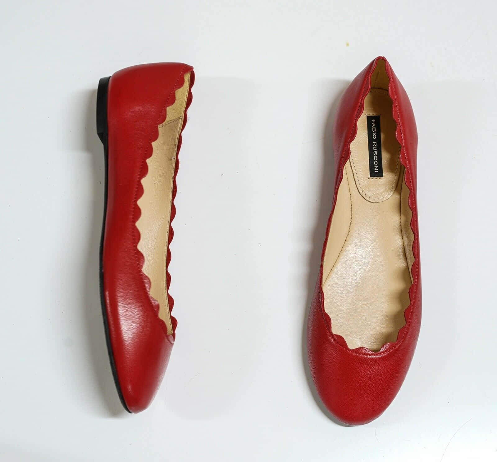 Red Shoes 桌布 壁紙 — 一對鮮紅色皮革平底鞋，帶有扇貝邊緣，展示在潔白背景上。