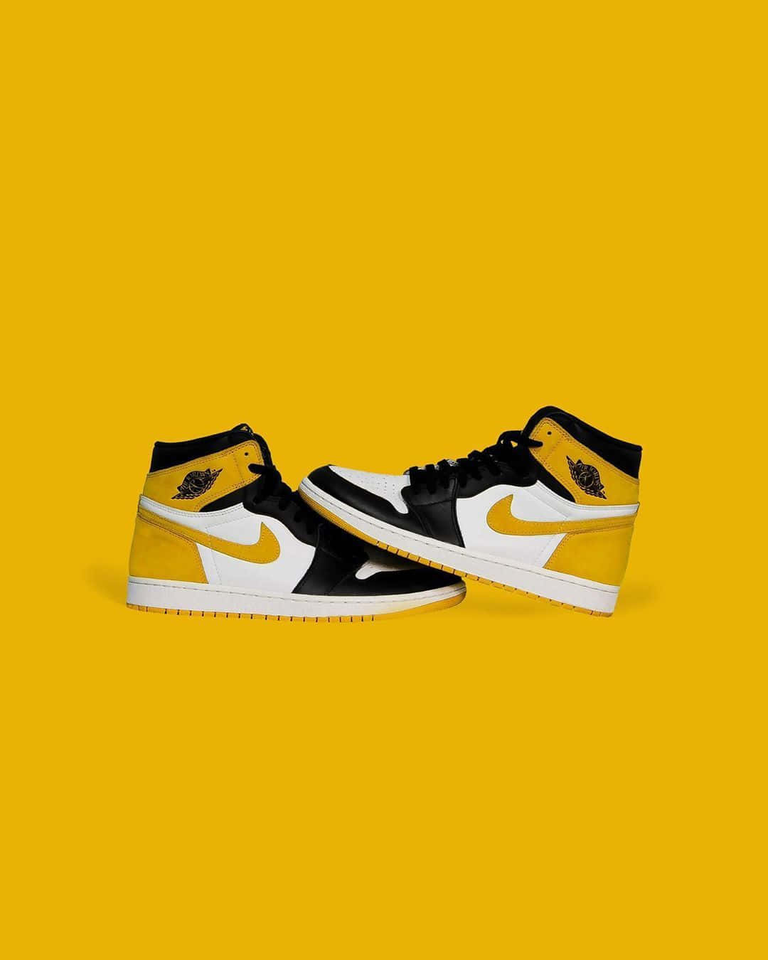 Yellow Jordan 桌布 壁紙 — 一對黑、白、黃色高筒運動鞋傾斜放置在純黃色背景上。