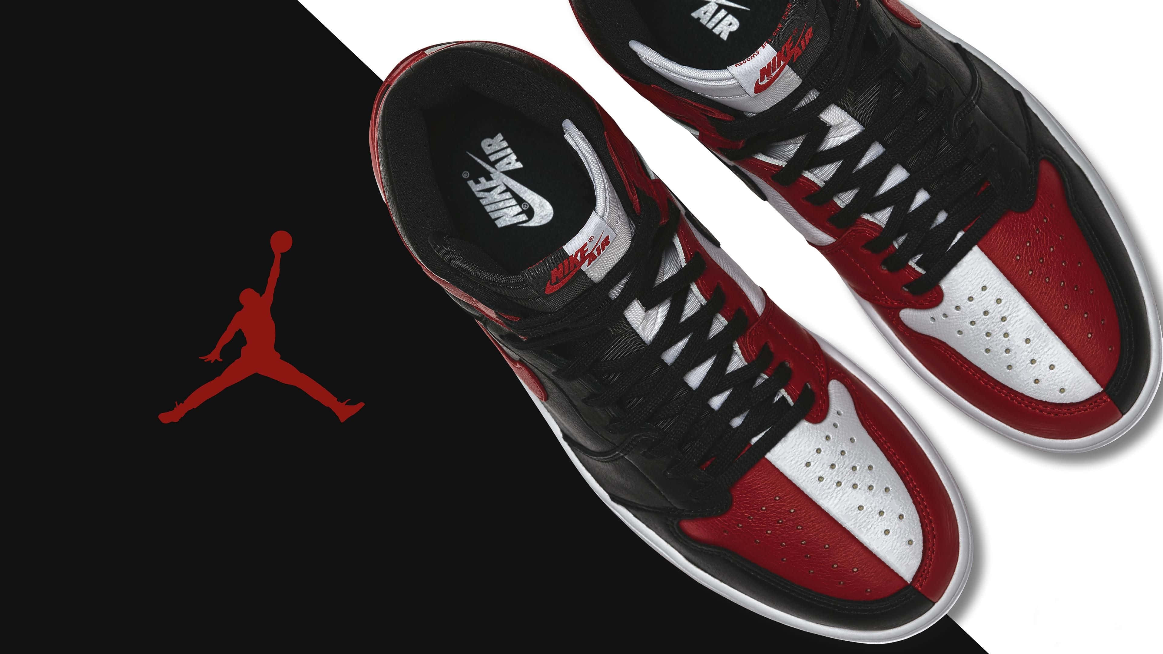 Sneakers 桌布 壁紙 — 一對黑紅白色的 Air Jordan 1 運動鞋，展示在分割的黑白背景上，帶有紅色 Jumpman 標誌。