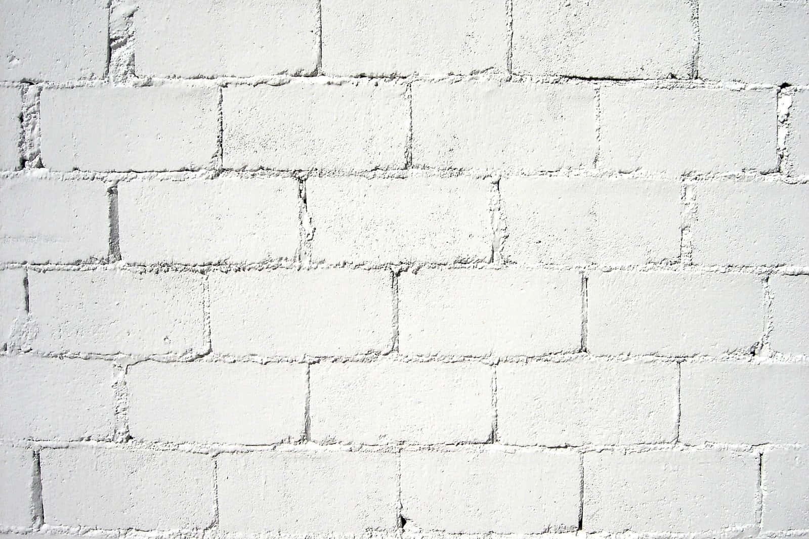 White Wall 桌布 壁紙 — 一幅乾淨白色油漆磚牆的特寫，顯示出紋理灰泥線條和微妙的表面瑕疵。