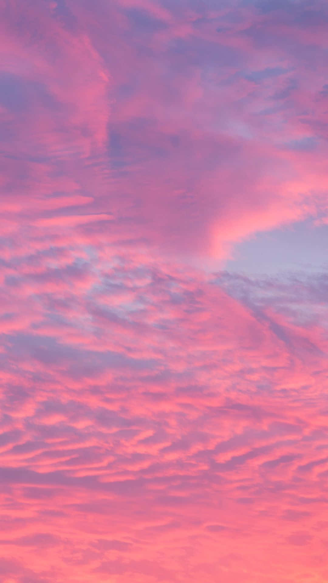 Clouds Aesthetic Tumblr 桌布 壁紙 — 一幅令人屏息的天空，以鮮豔的粉紅和薰衣草色調繪製，雲彩在黎明時分戲劇性地旋轉。