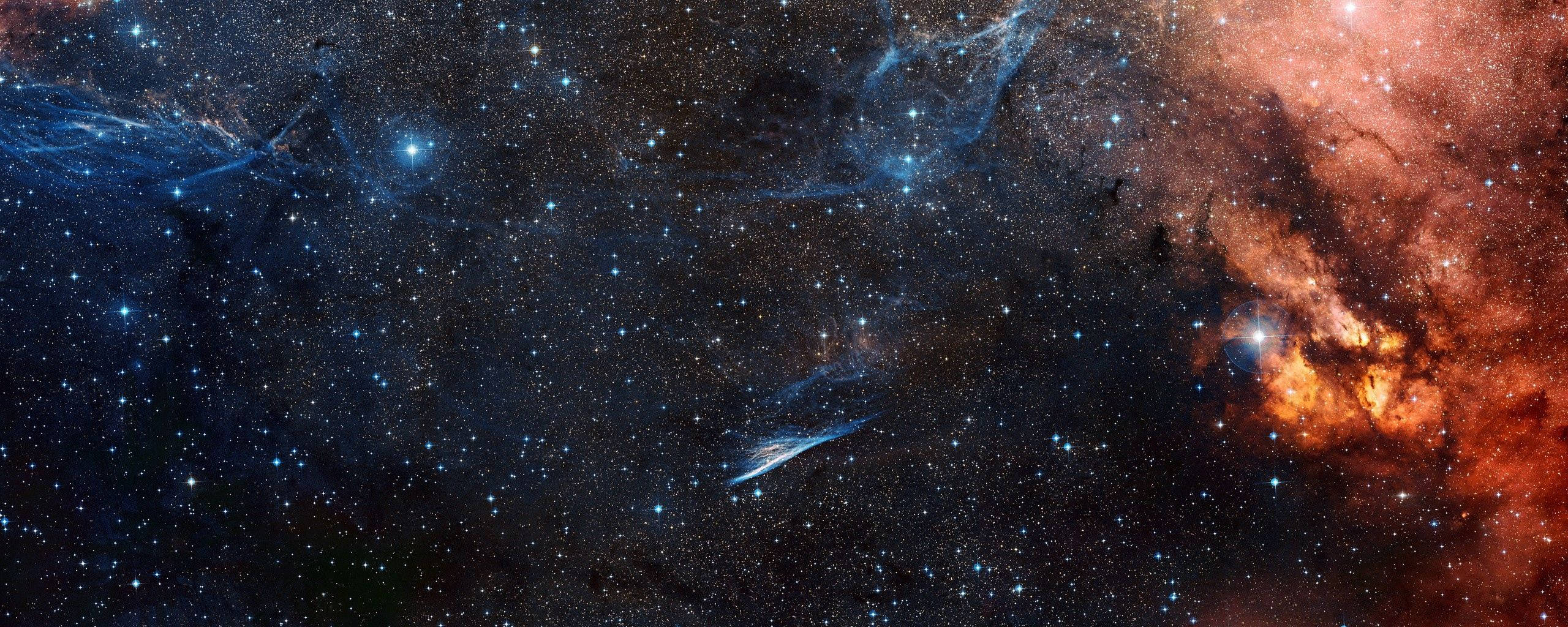 外太空 桌布 壁紙 — 一幅令人驚嘆的宇宙景象，展現了在深邃黑色太空背景下，無數閃爍星辰之間 swirling 著 vibrant 藍色和 fiery 橙色星雲。